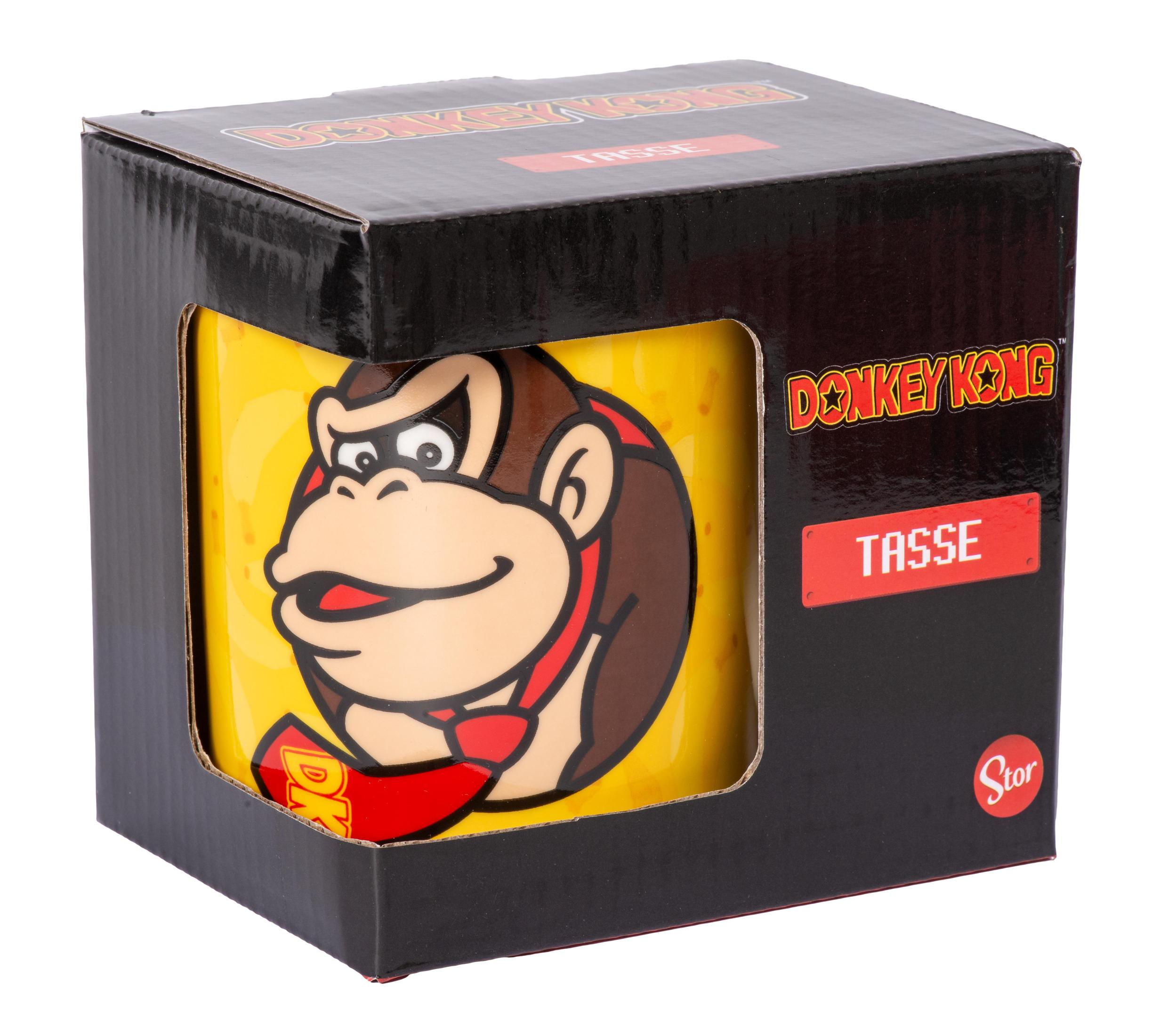Donkey Kong Tasse in einer Box. Gelbe Tasse mit Donkey Kongs Gesicht. Schwarze Box mit rotem Text.