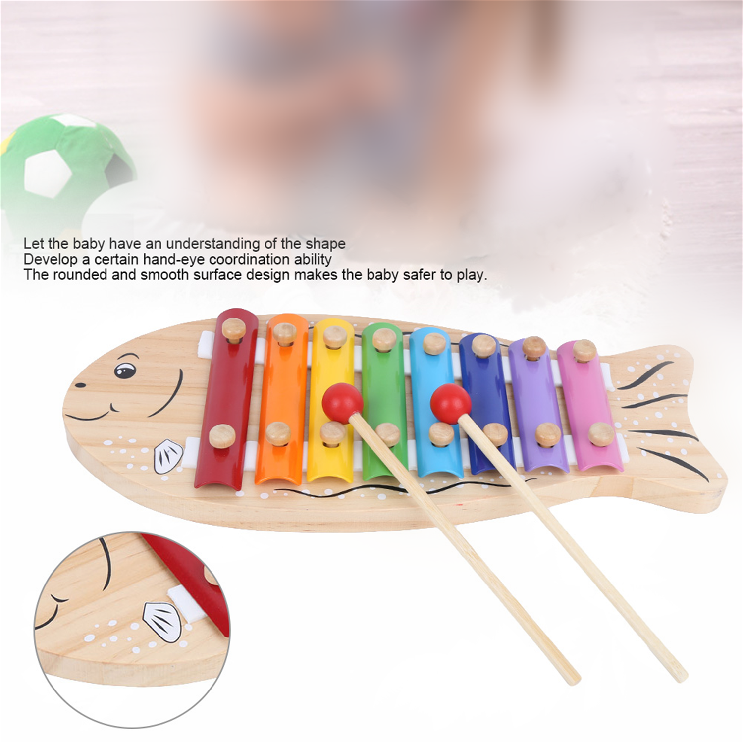 Holzspielzeug-Xylophon in Fischform mit Schlägeln. Bunte Stäbe, weißer Hintergrund.