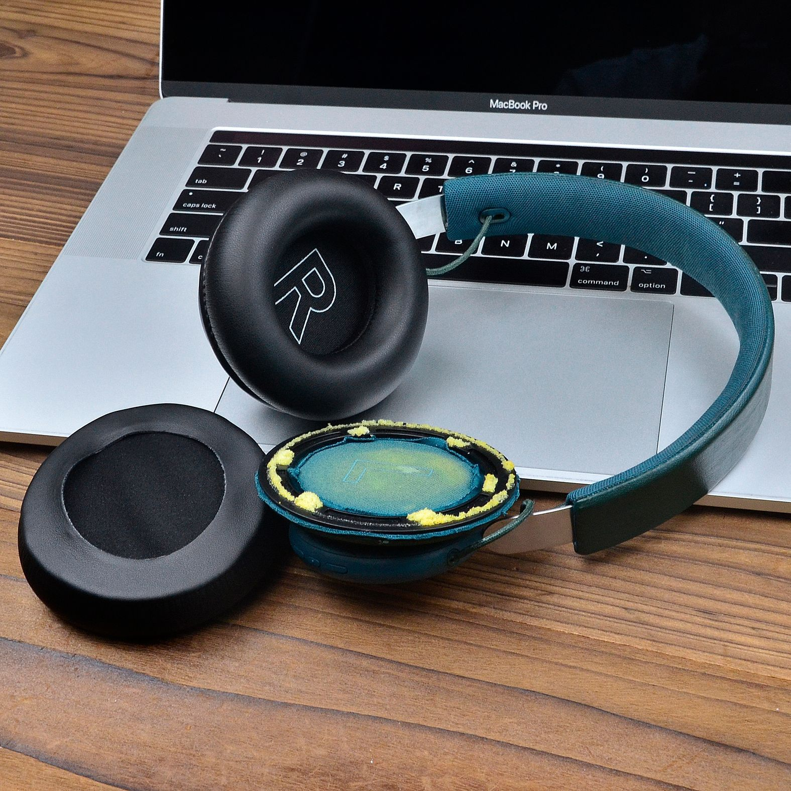 Słuchawki zdemontowane na laptopie, z nausznikami i pałąkiem.