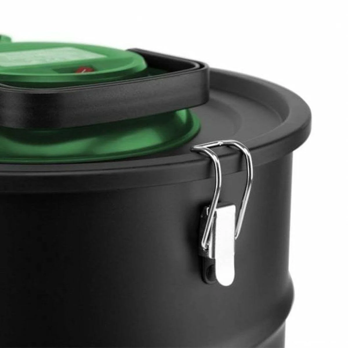A close-up of a black container with a green lid. The container has a handle.
