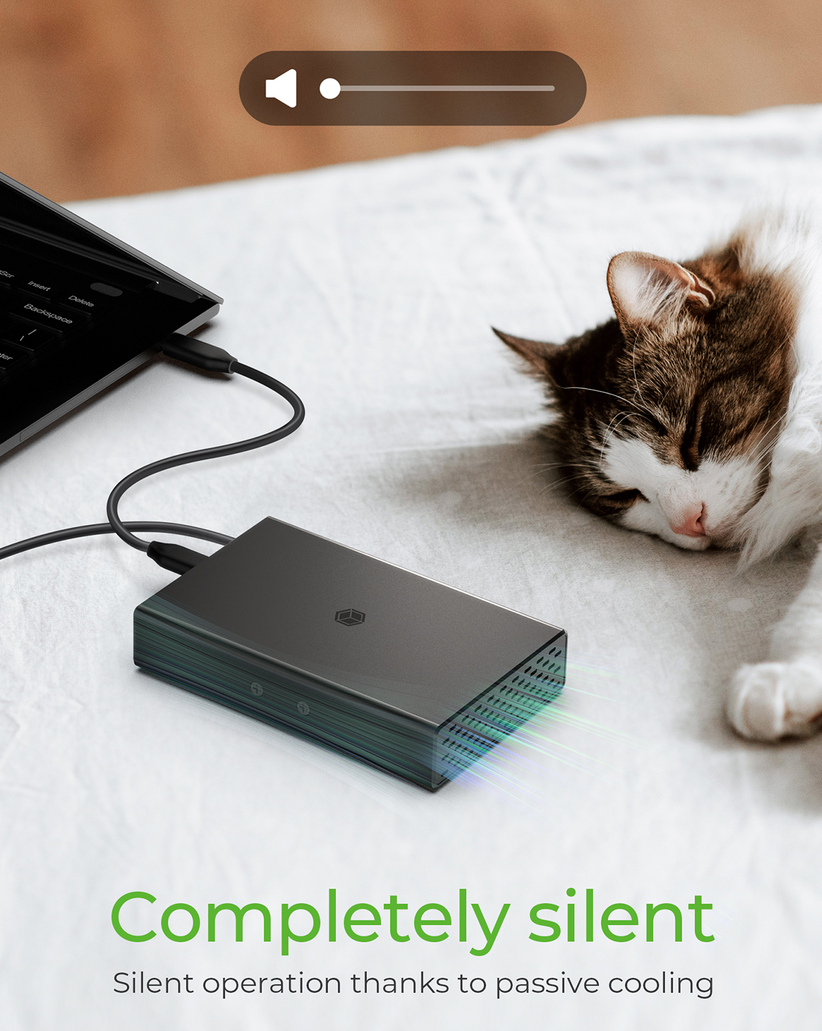 Ein Laptop, der an einen schwarzen Hub angeschlossen ist, mit einer schlafenden Katze auf dem Bett.