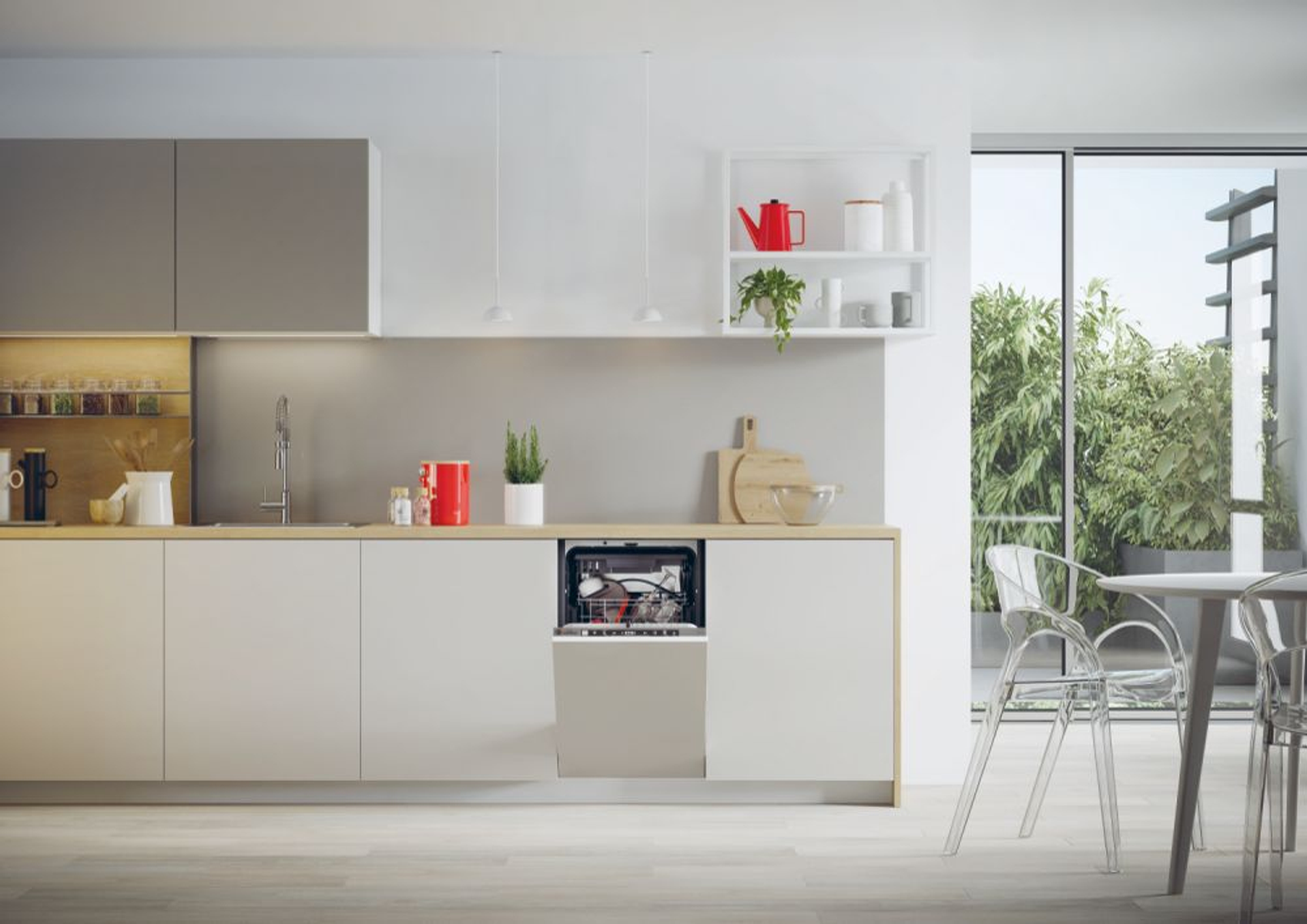 Cucina moderna con mobili chiari, lavastoviglie e finestra con piante verdi.