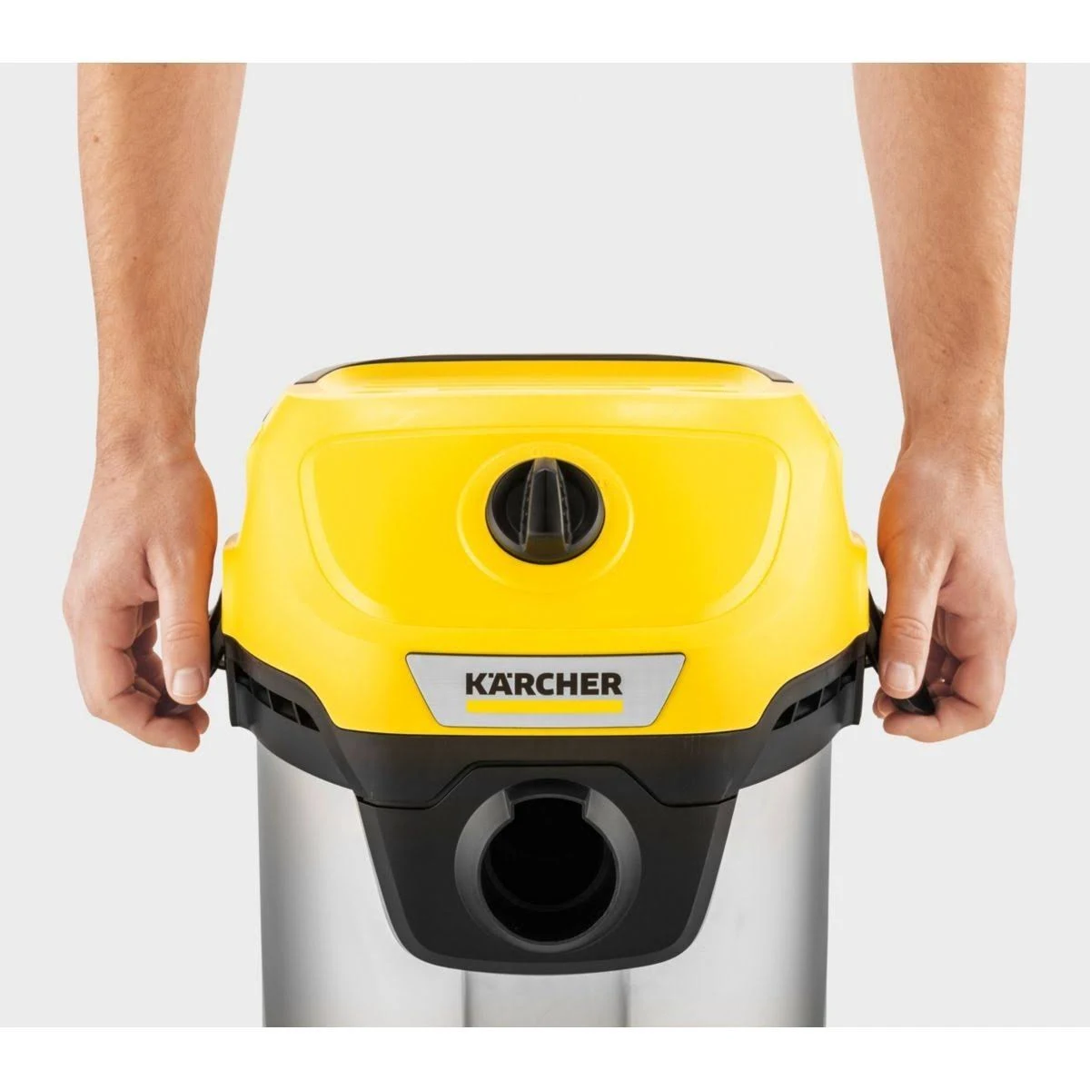 Persona sosteniendo el cuerpo amarillo y negro de una aspiradora Kärcher.