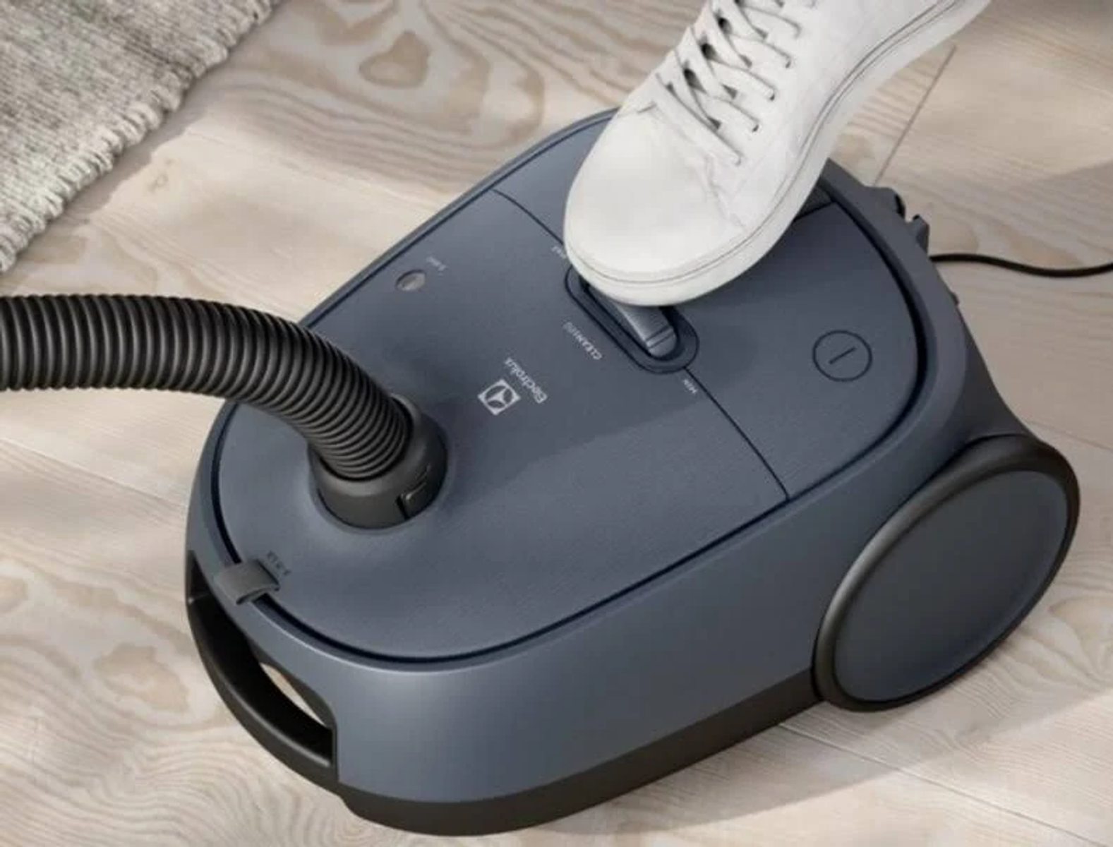 Biało-czarny odkurzacz Kärcher z wężem i dyszą na białym tle.