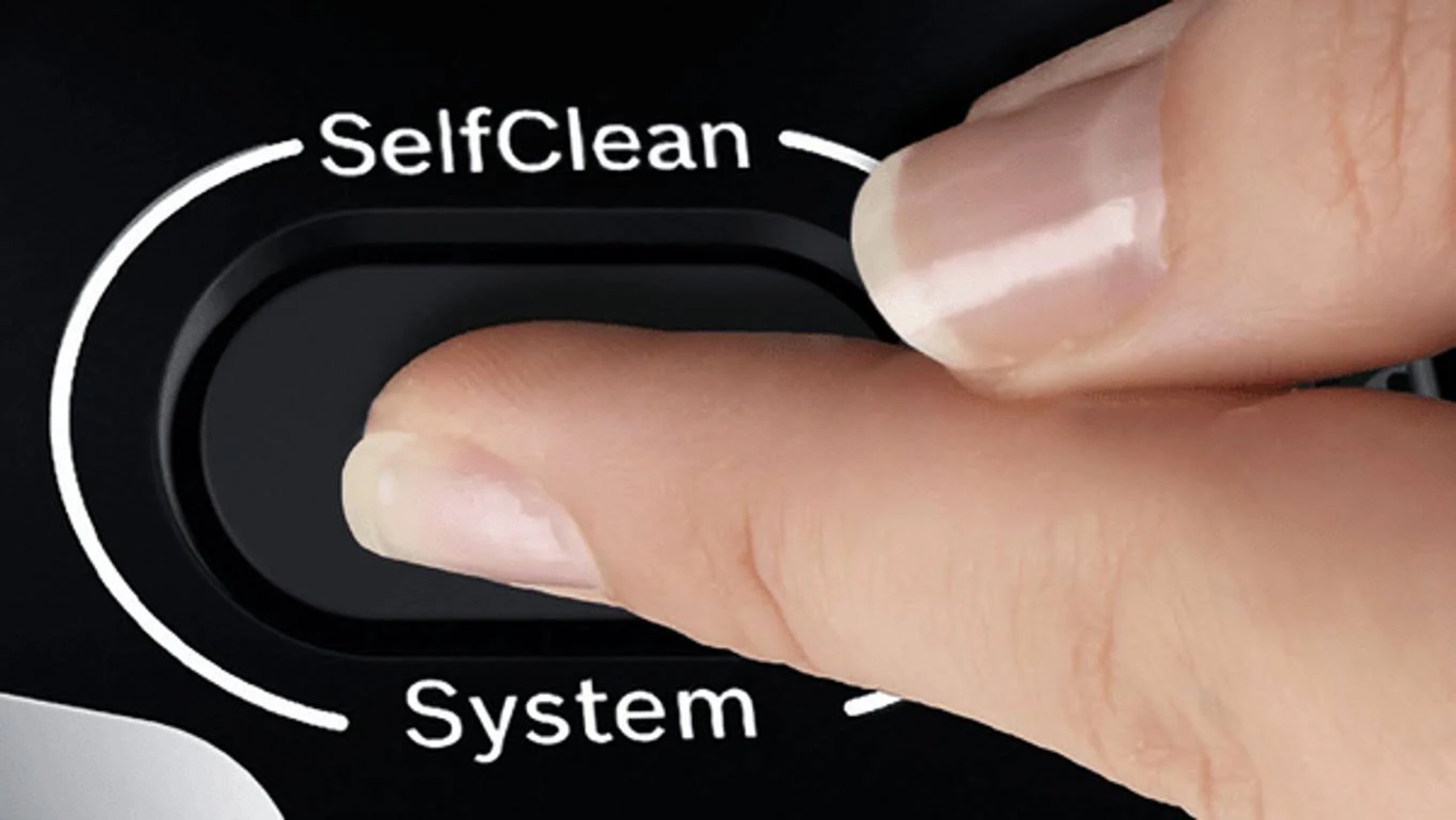 Parmak, SelfClean System yazılı siyah bir düğmeye basıyor. Bir makinenin parçası.