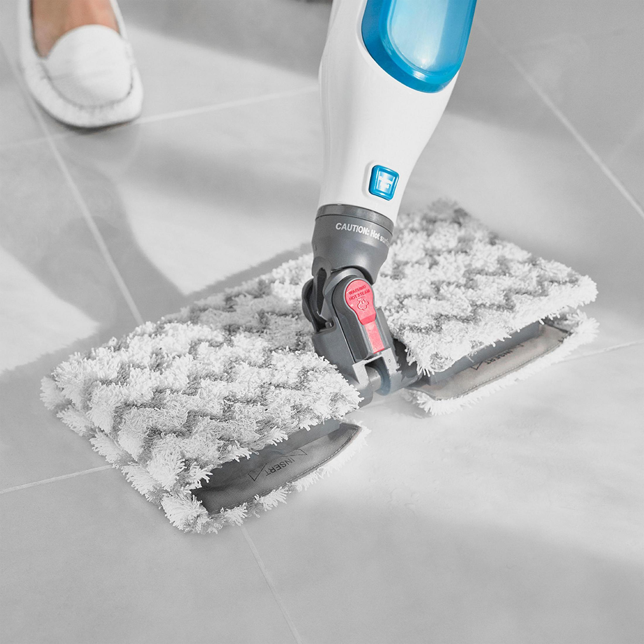 Osoba myjąca podłogę mopem parowym, zbliżenie.