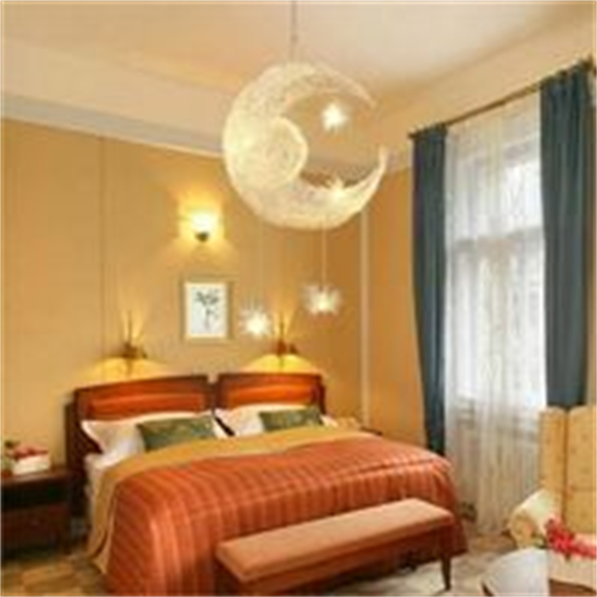 Schlafzimmer mit mondförmiger Lampe, Bett und Vorhängen. Der Raum ist beige mit roter und orangefarbener Bettdecke.