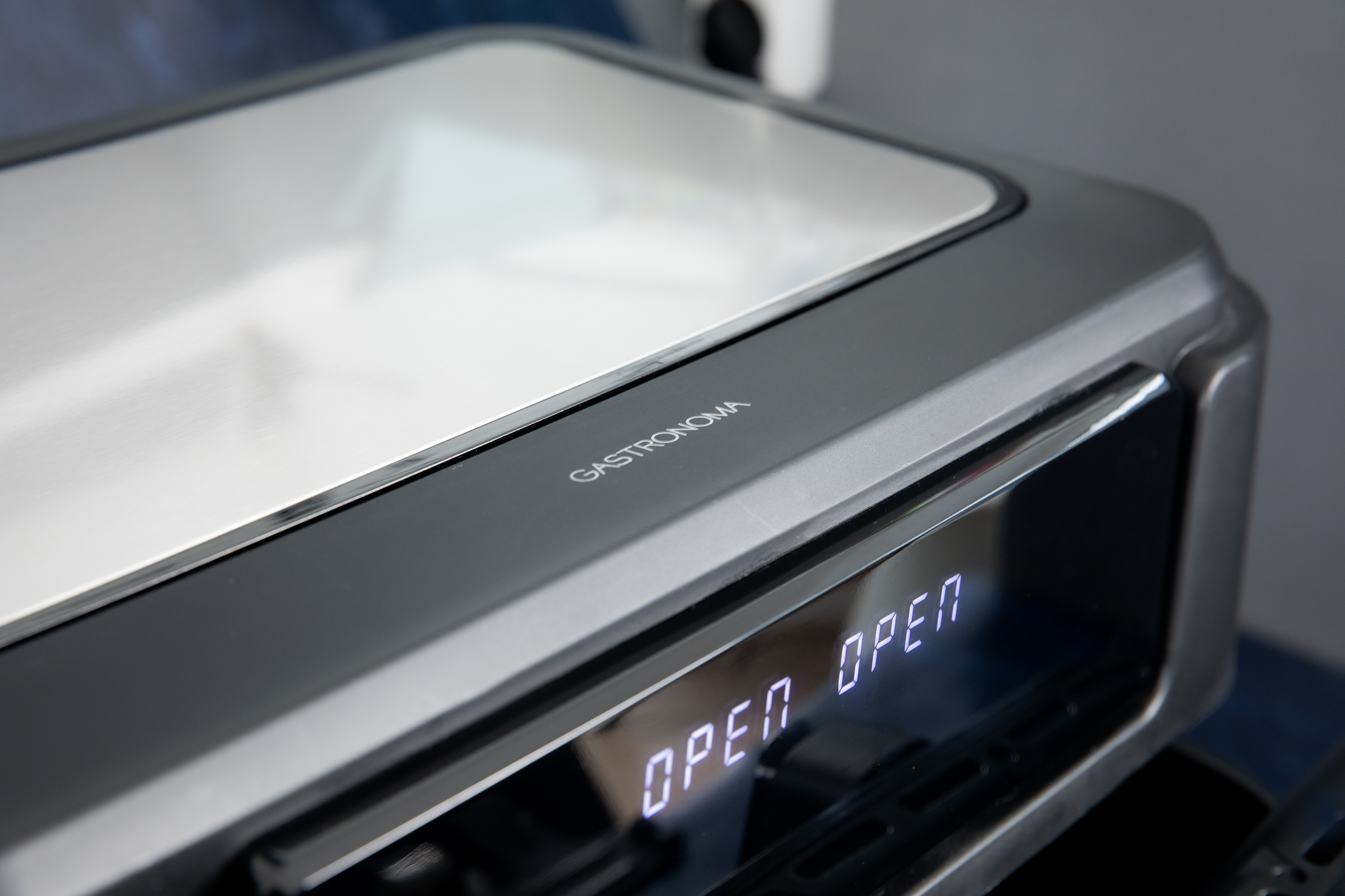 Zbliżenie szarego robota kuchennego ze słowem 'GASTRONOMIA'.