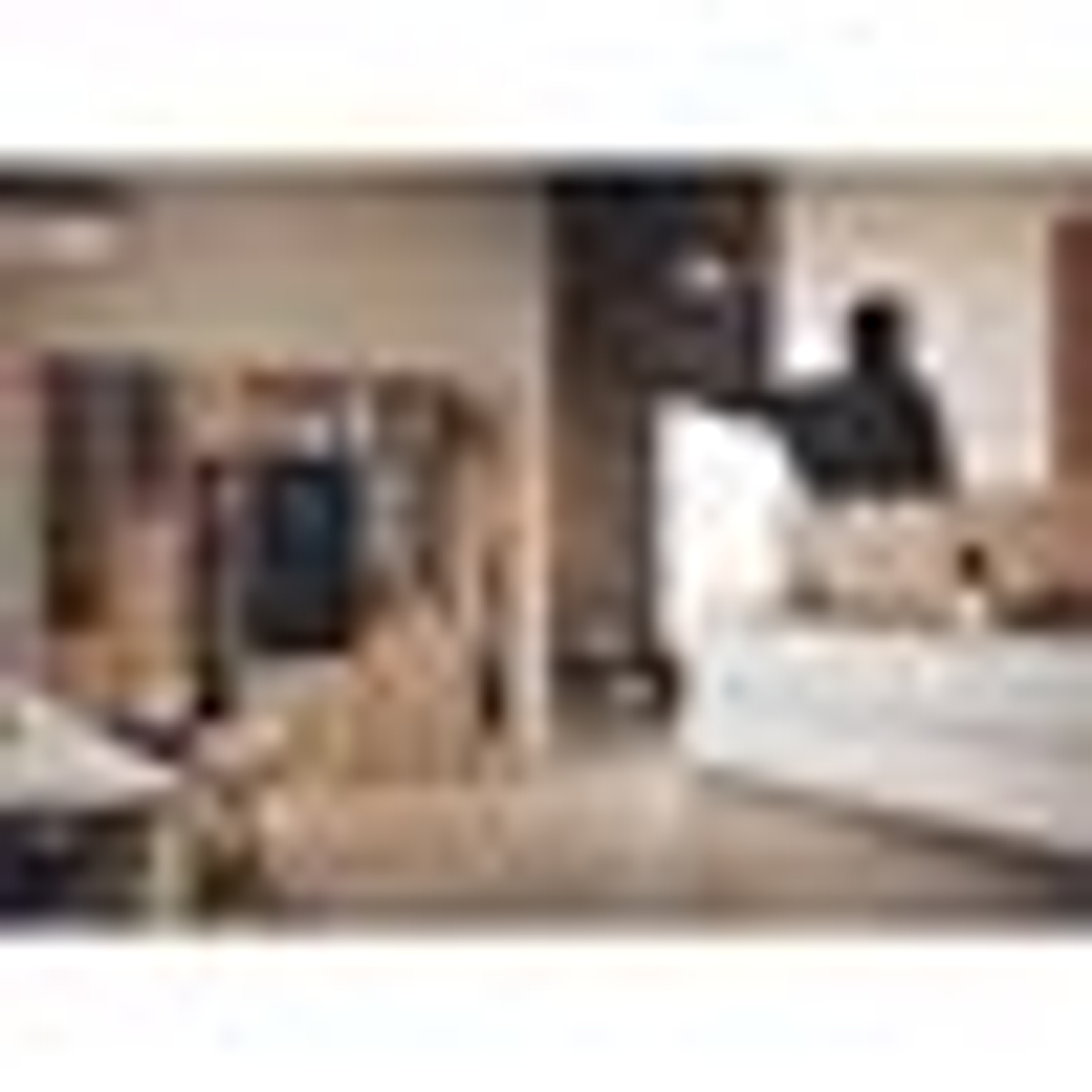 Rozmyte zdjęcie pokoju z osobą, stołem i oknem.