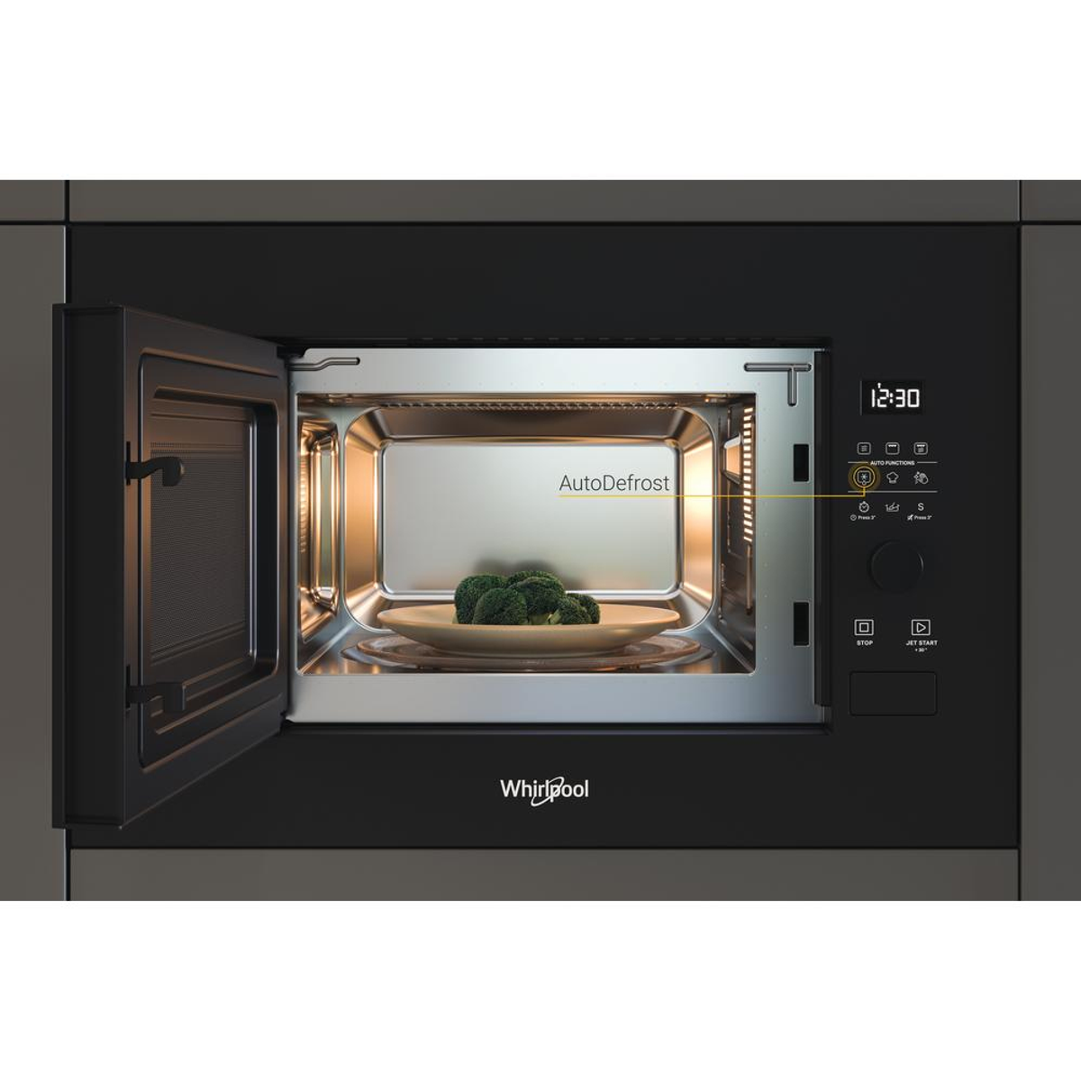 Whirlpool magnetron met open deur, broccoli op een bord. Bedieningspaneel en display zichtbaar.