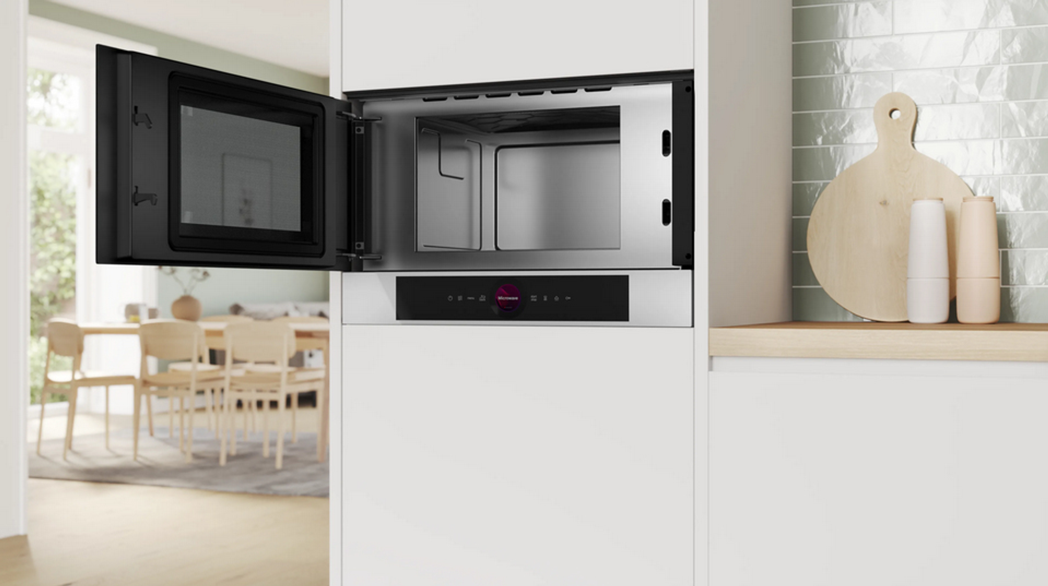 Wbudowana kuchenka mikrofalowa z otwartymi drzwiami, pokazująca wnętrze. Drewniana deska do krojenia.