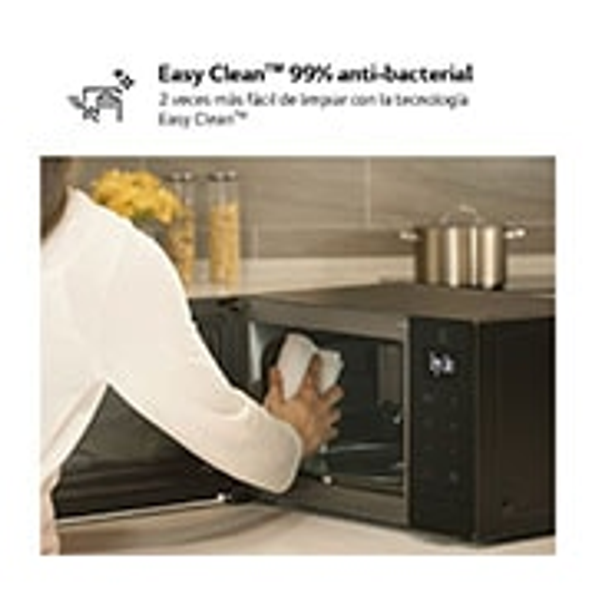 Osoba czyszcząca wnętrze kuchenki mikrofalowej. Tekst: Easy Clean 99% antybakteryjny.