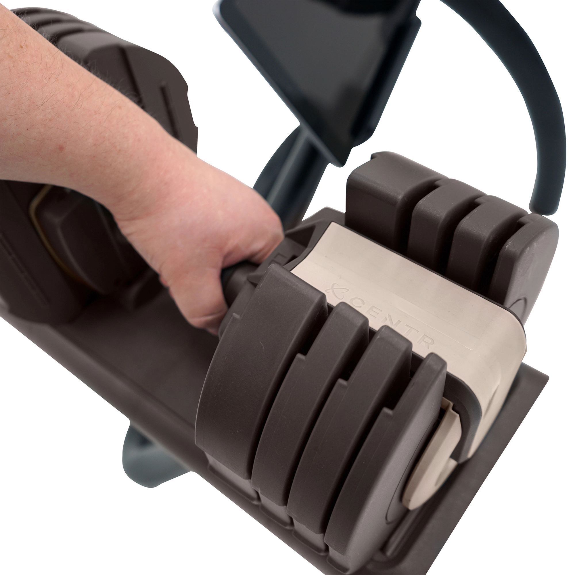 De hand van een persoon die een halter vasthoudt met verstelbare gewichten, bruine en beige kleuren.