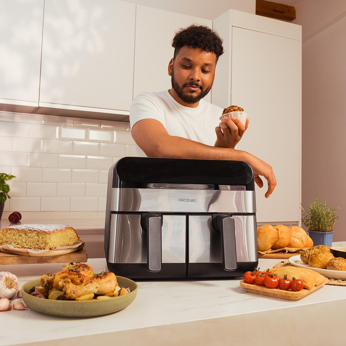 Mężczyzna trzymający muffina obok frytkownicy. Widoczne ciasto i kurczak.