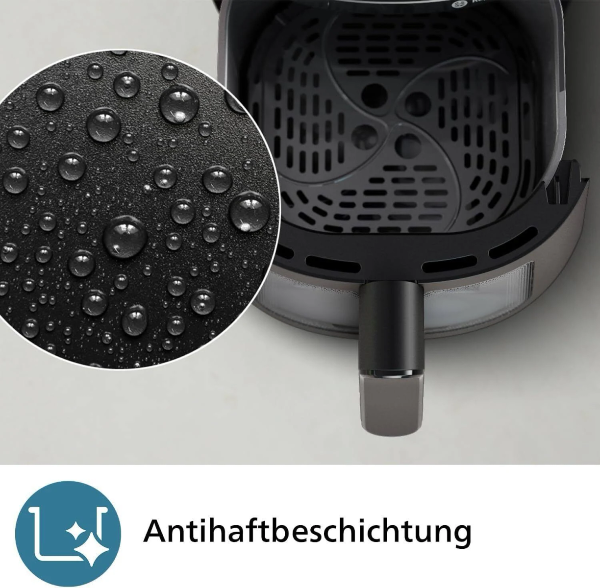 Heißluftfritteuse Innenraum mit Wassertröpfchen und einem Etikett: 'Antihäftbeschichtung'.