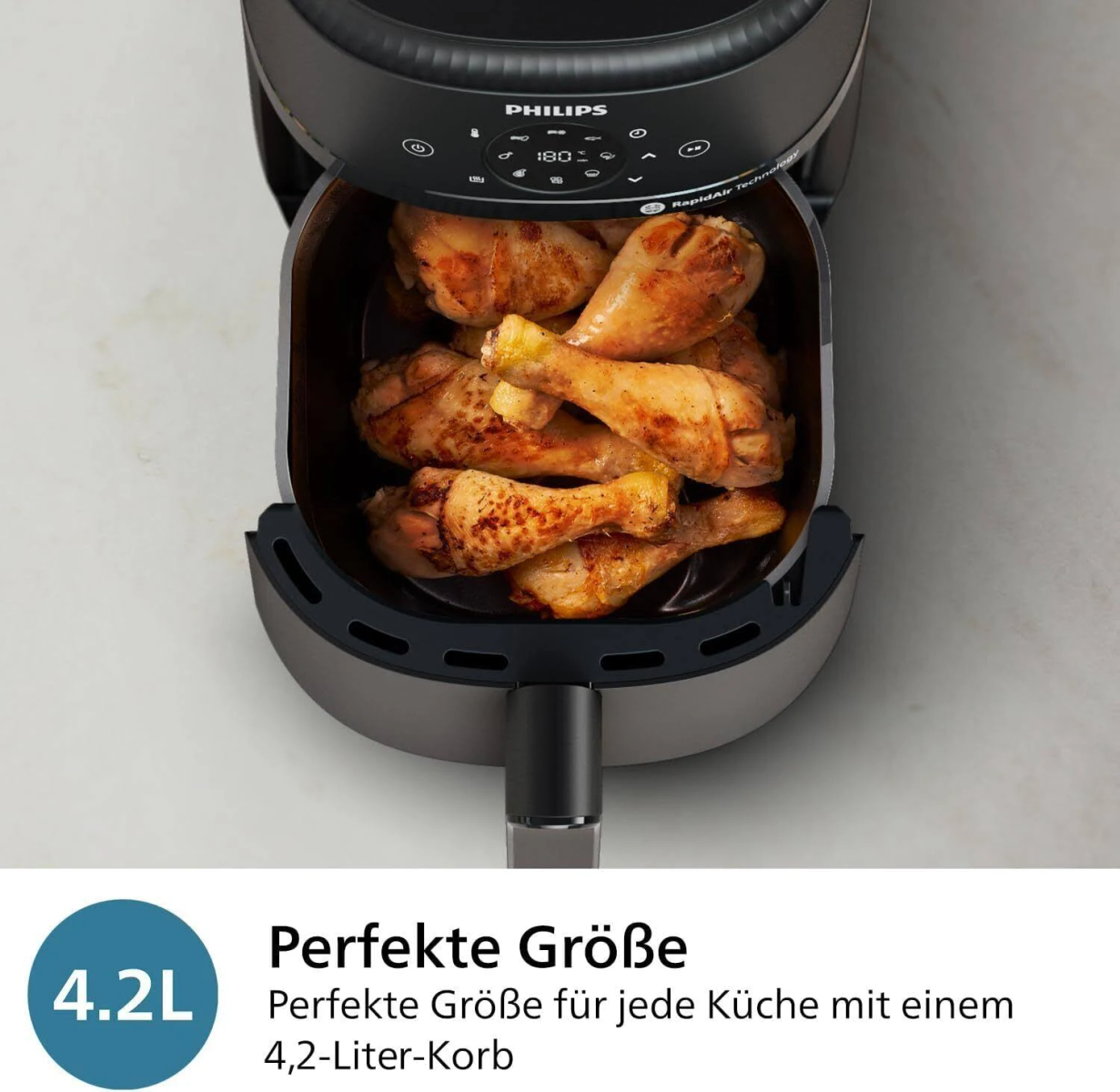Eine Heißluftfritteuse mit gekochten Hähnchenkeulen. Text zeigt 4,2L Kapazität.