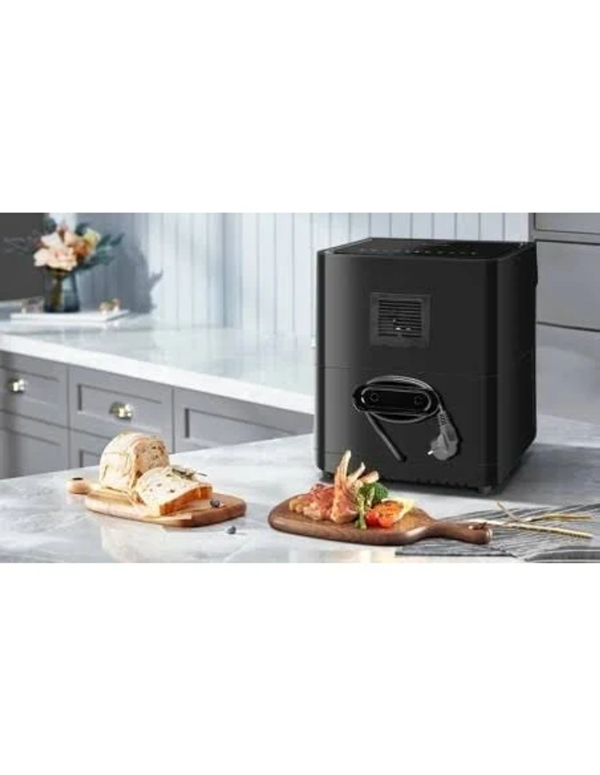 Friggitrice ad aria nera su un piano di lavoro con cibo. Fette di pane e carne su assi di legno.