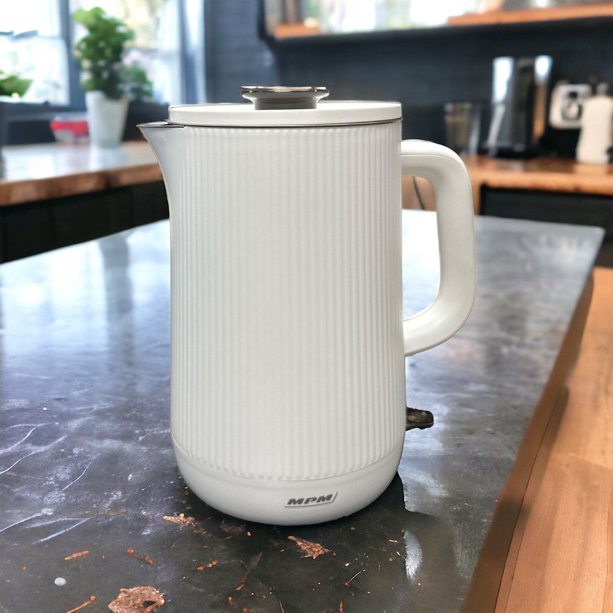 Bollitore elettrico bianco su un piano di lavoro, con un design elegante e sfondo cucina.