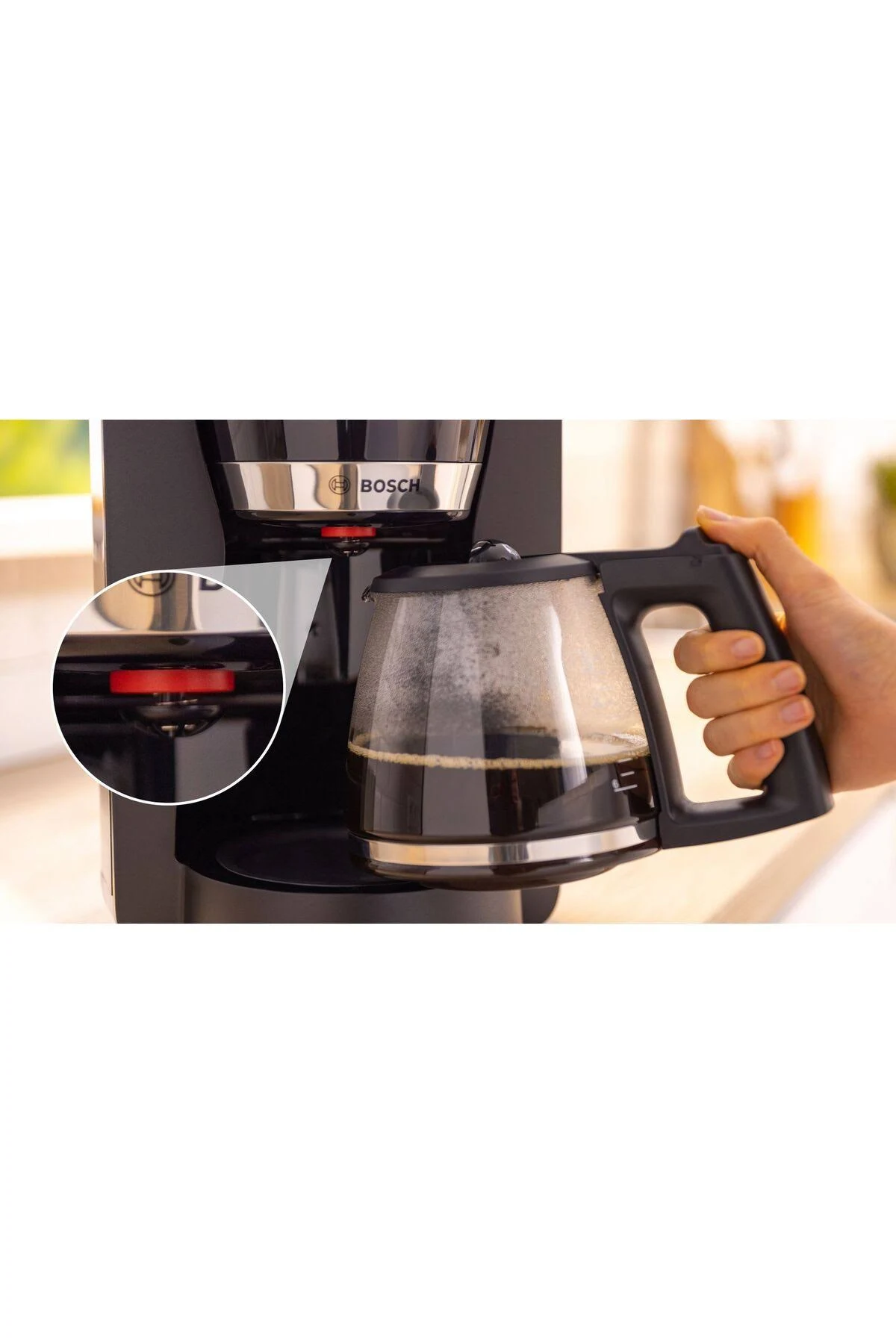 Zbliżenie czarnego ekspresu do kawy ze szklaną karafką wypełnioną kawą.