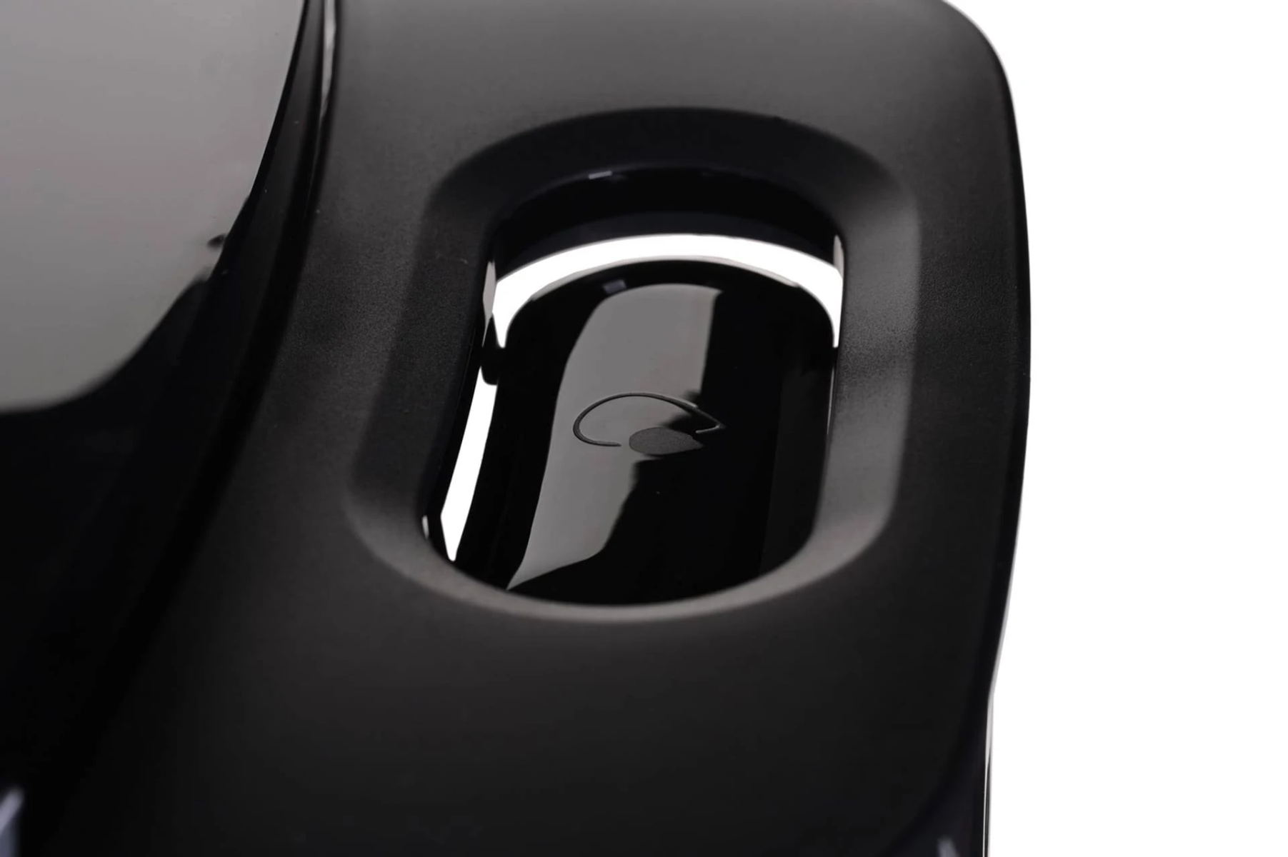 Zbliżenie ekspresu do kawy. Czarna powierzchnia z małym wlotem wody.