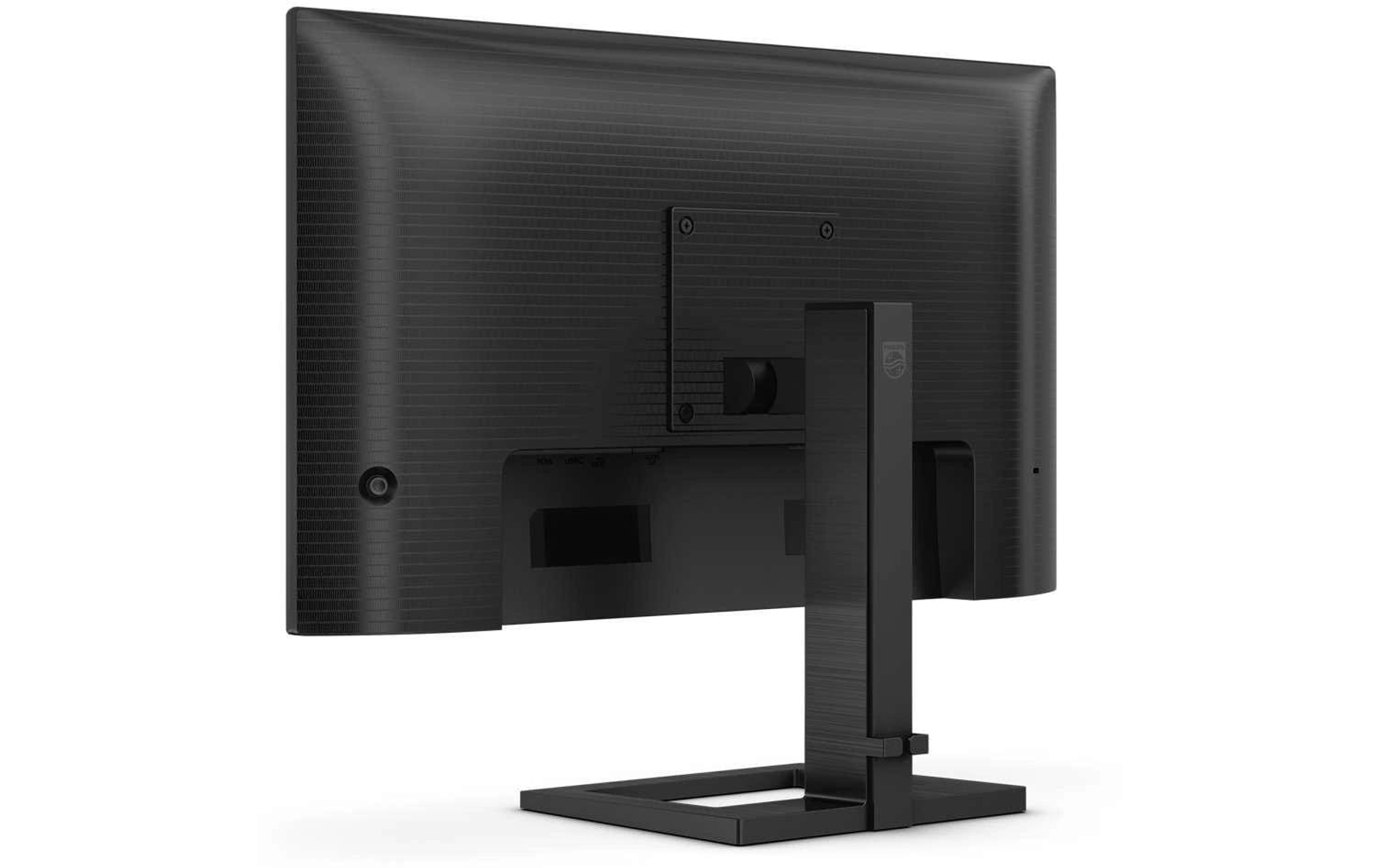 Widok z tyłu czarnego monitora komputera z czarną podstawą, porty widoczne na dole.