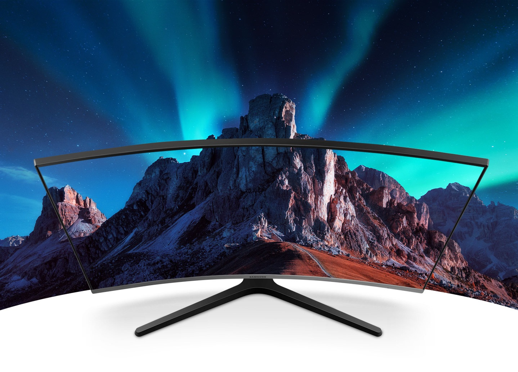 Monitor curvo con immagine di paesaggio montano come sfondo su una superficie bianca.