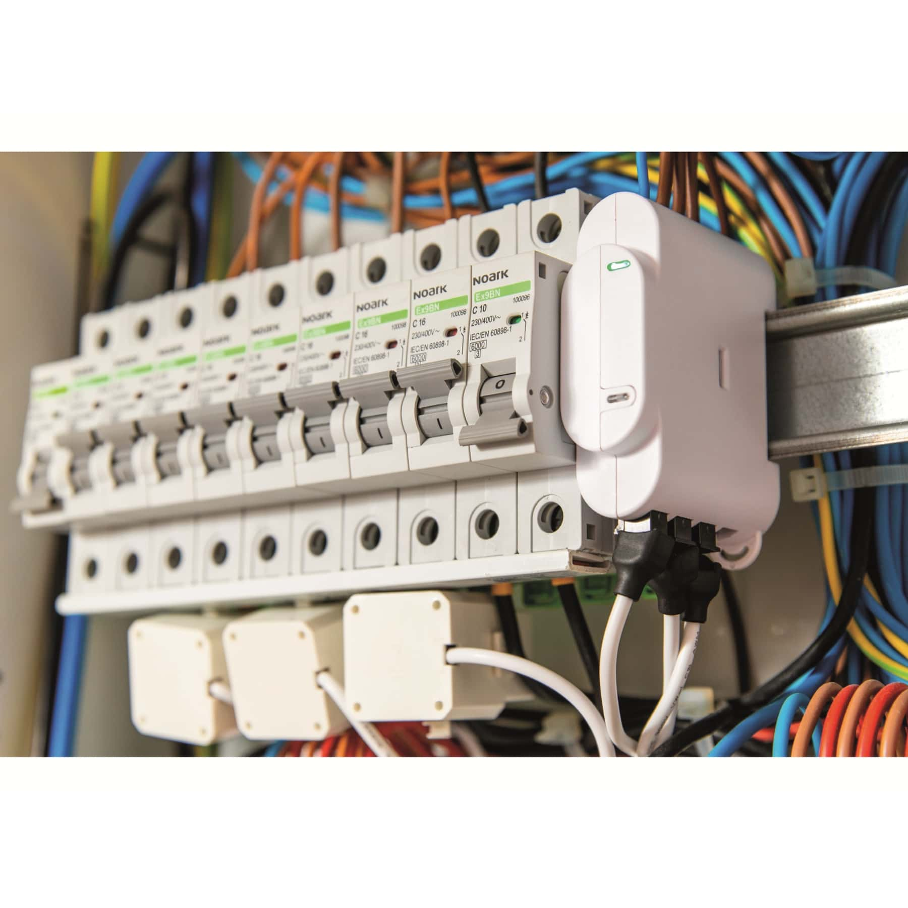 Primer plano de interruptores automáticos y cables eléctricos dentro de un panel.