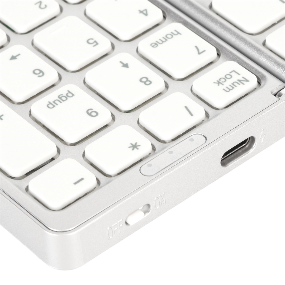 Nahaufnahme einer silbernen Tastatur mit weißen Tasten. Mit Netzschalter und USB-Anschluss.