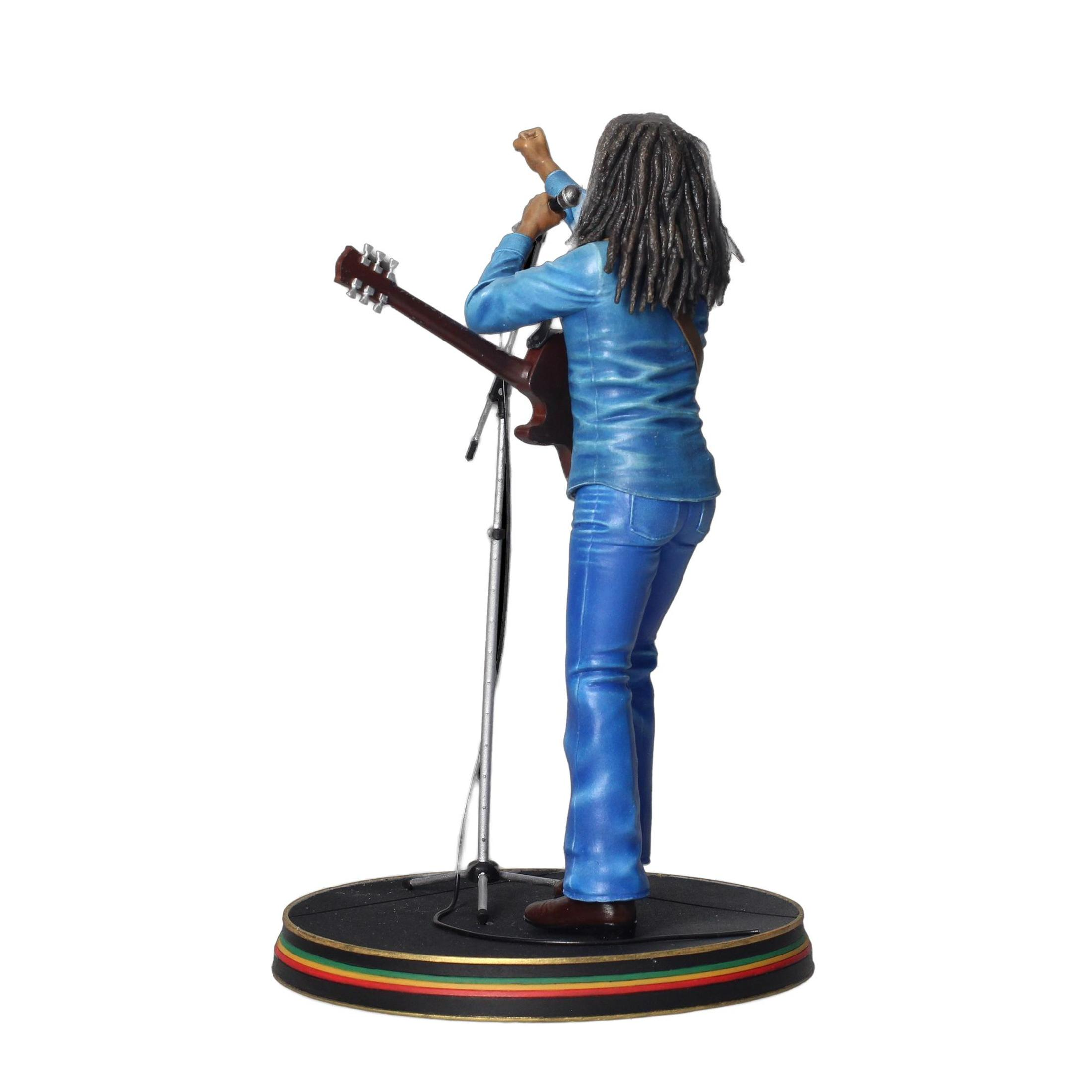 Estatua de Bob Marley cantando y tocando la guitarra en un escenario redondo con los colores rastafari.