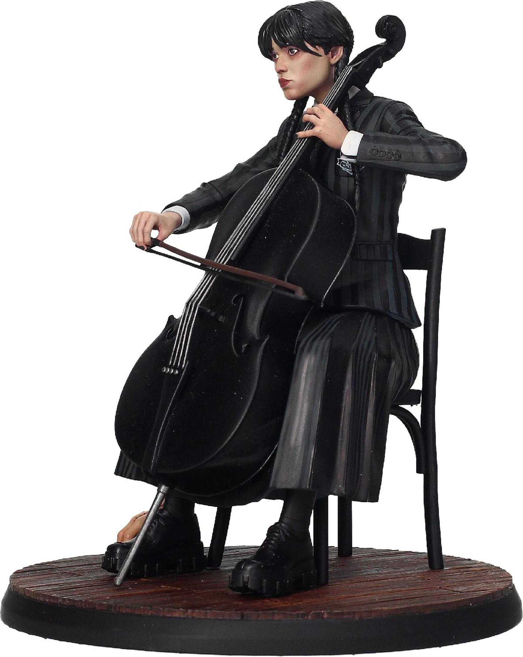 Estatua de una mujer tocando el violonchelo. Lleva un traje a rayas y está sentada.