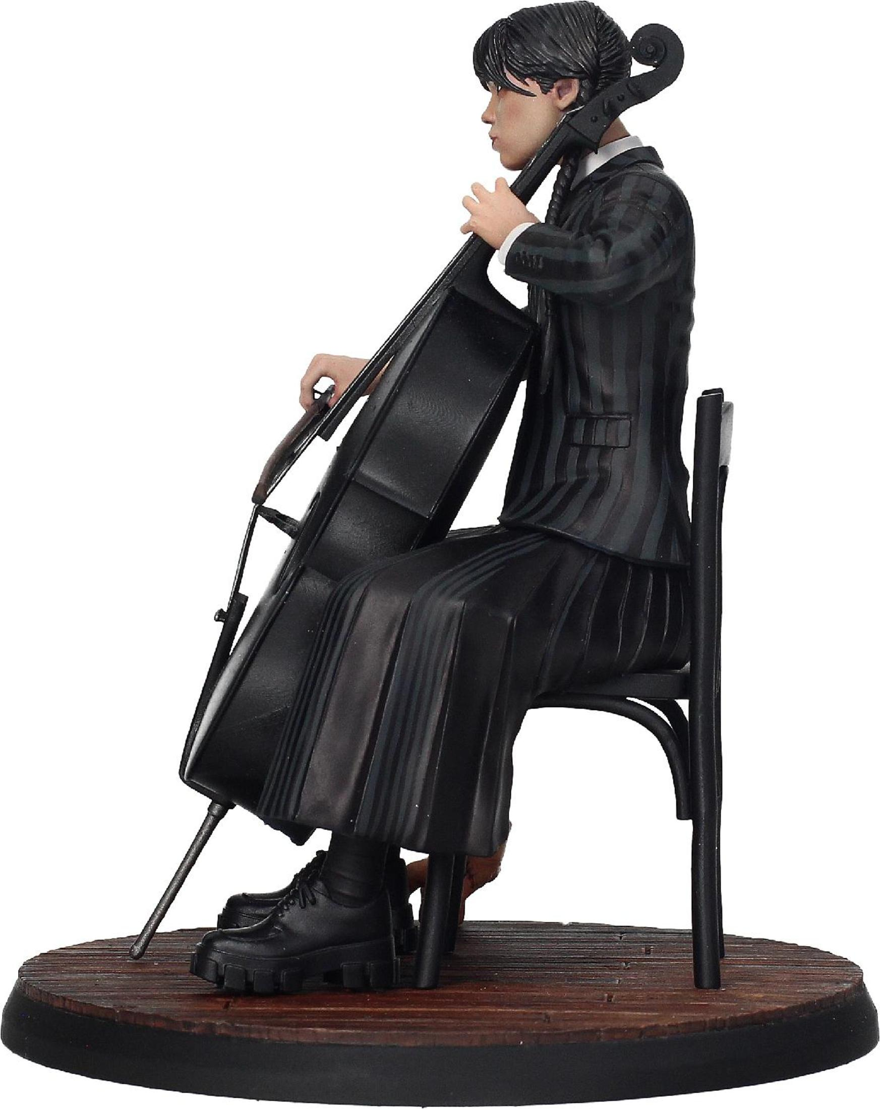 Una figura de una mujer tocando el violonchelo. Viste un traje negro y está sentada en una silla.