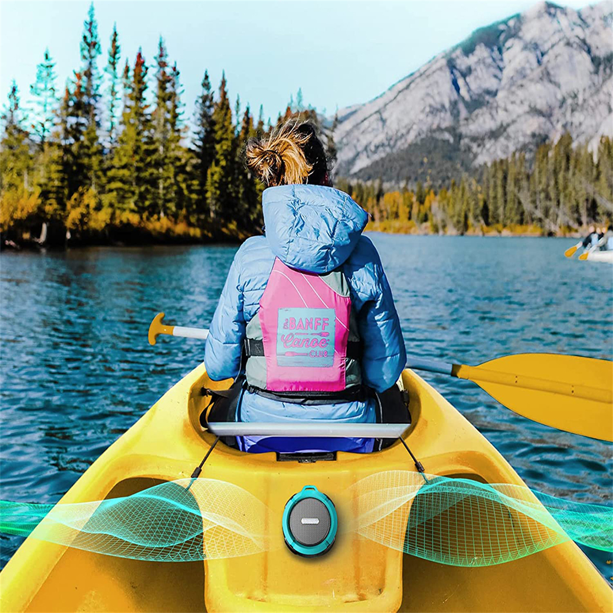 Frau im Kajak auf dem See, Berge im Hintergrund.