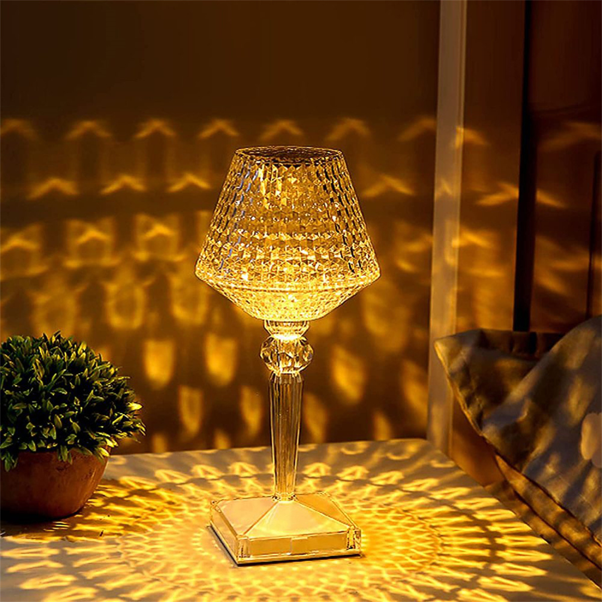 Kristalllampe auf einem Tisch, wirft Lichtmuster. Links eine Pflanze.
