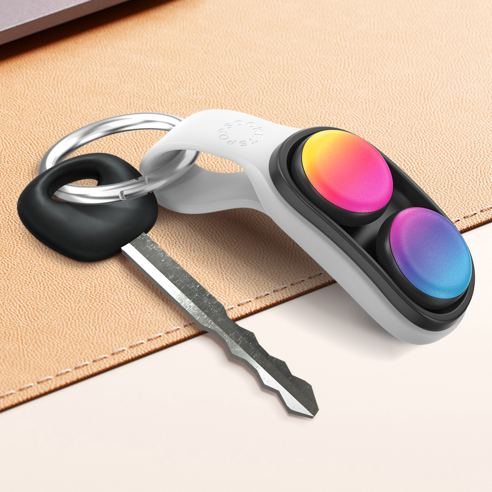 Portachiavi bianco con chiave ed etichetta PopSockets con bottoni sfumati su superficie beige.