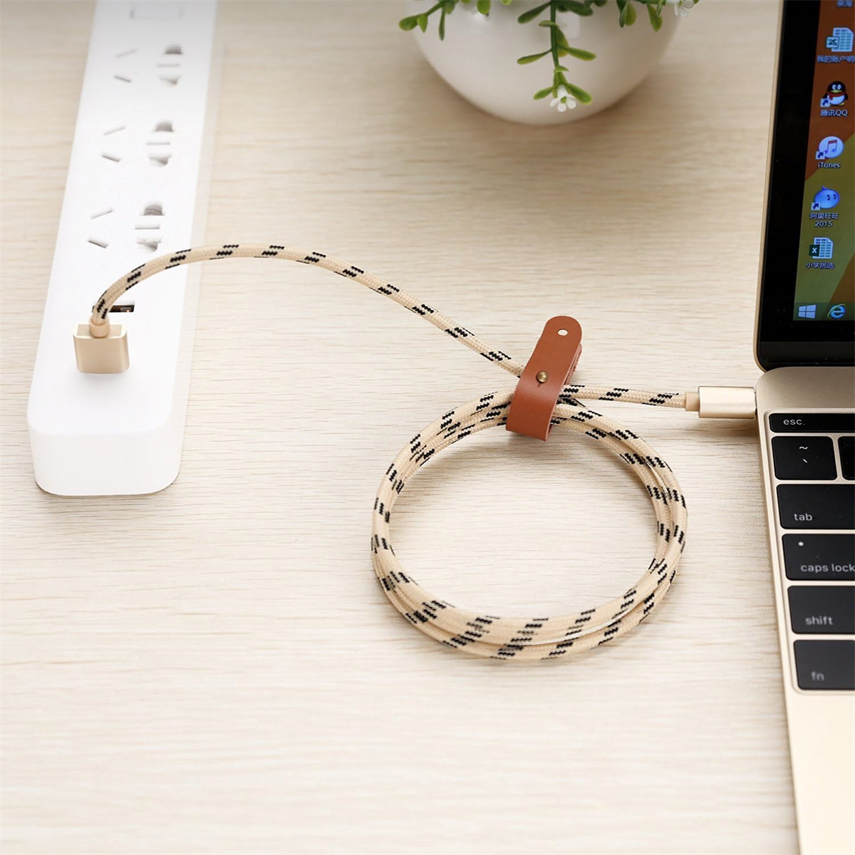 Ein Kabel, das mit einem Laptop und einer Steckdosenleiste mit Kabel-Organizer verbunden ist.