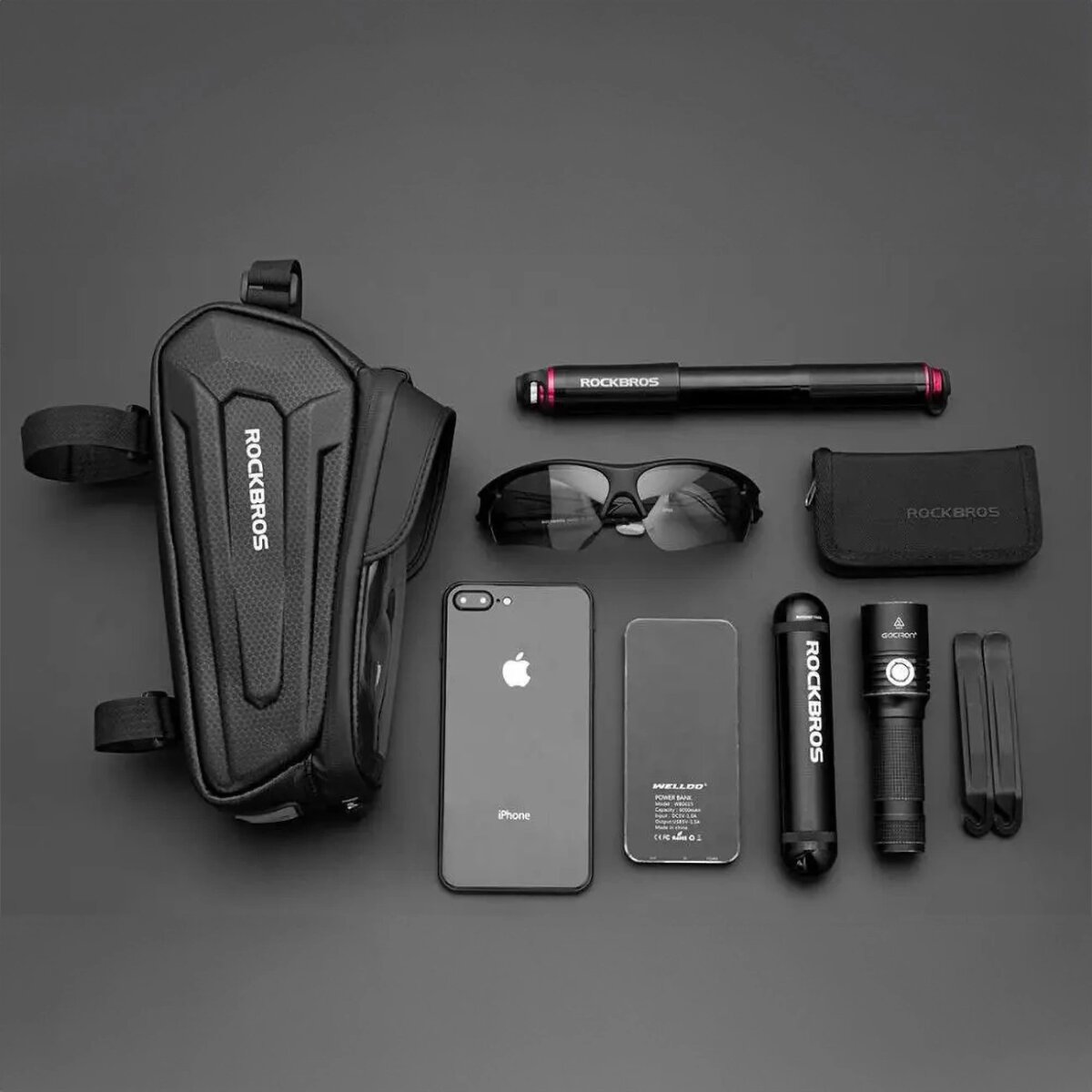 Borsa da bici nera, occhiali da sole, telefono, power bank, pompa e altri accessori per il ciclismo.