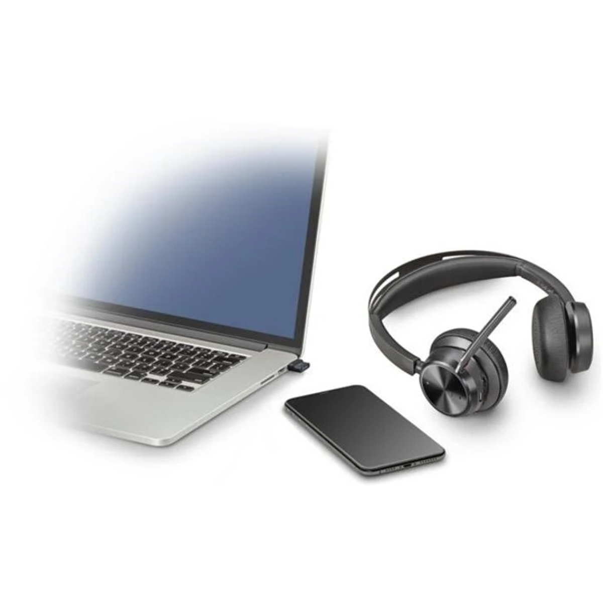 Una computadora portátil, un teléfono y unos auriculares están colocados sobre una superficie blanca. Los auriculares son negros.