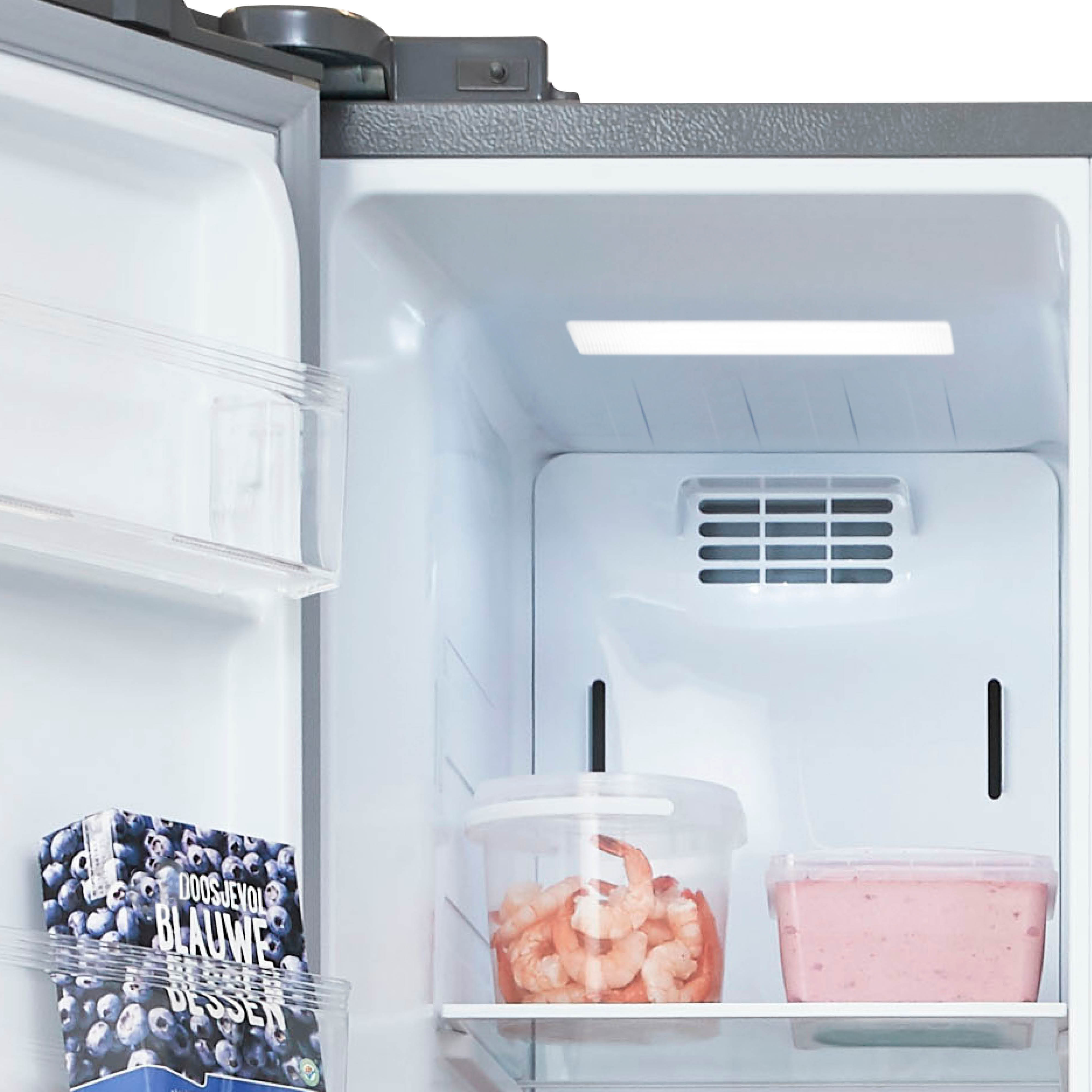 Refrigerator interior. Blueberries, shrimp, and food containers inside. White background.