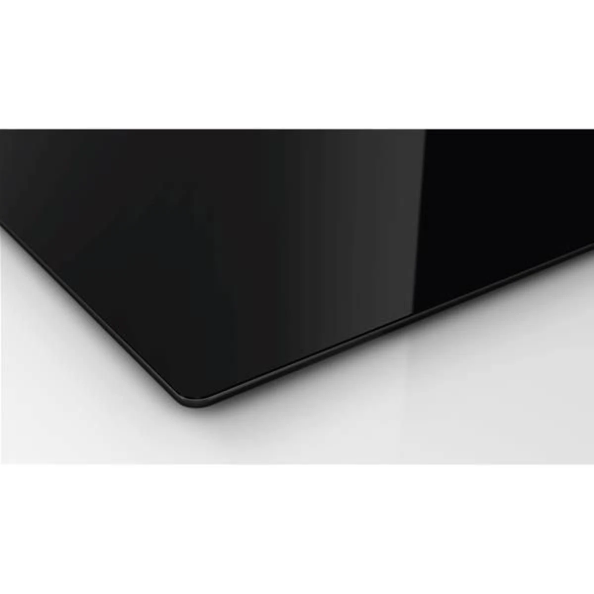 Primer plano de una superficie de vidrio negro. Es una esquina de una superficie rectangular, negra y brillante.
