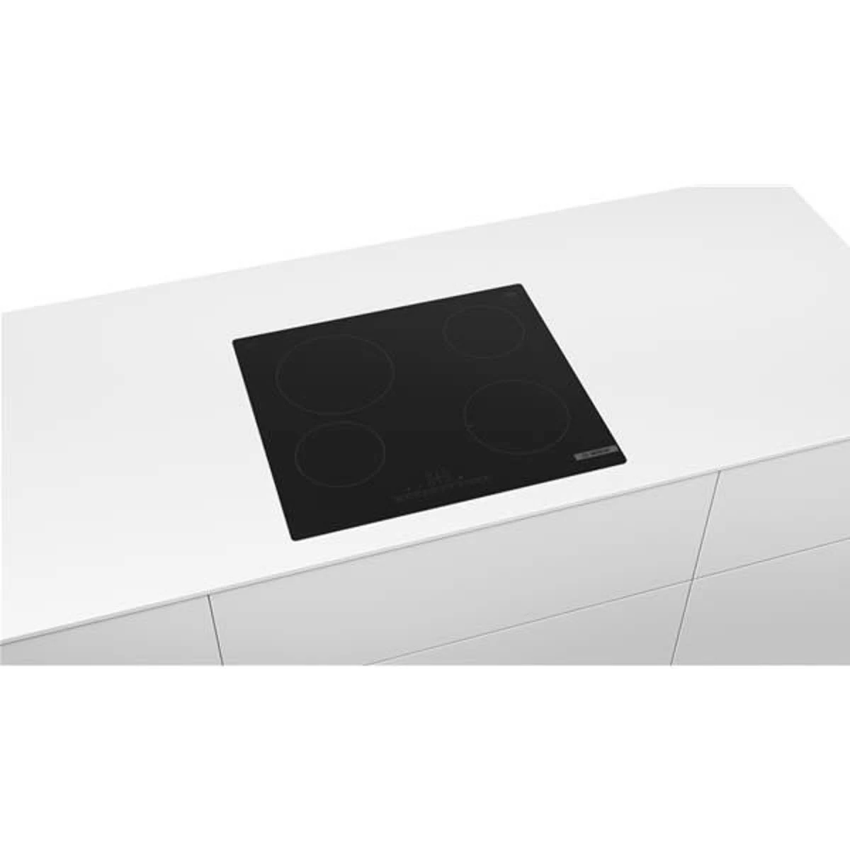 Placa de inducción negra sobre encimera blanca. Cuatro zonas de cocción.