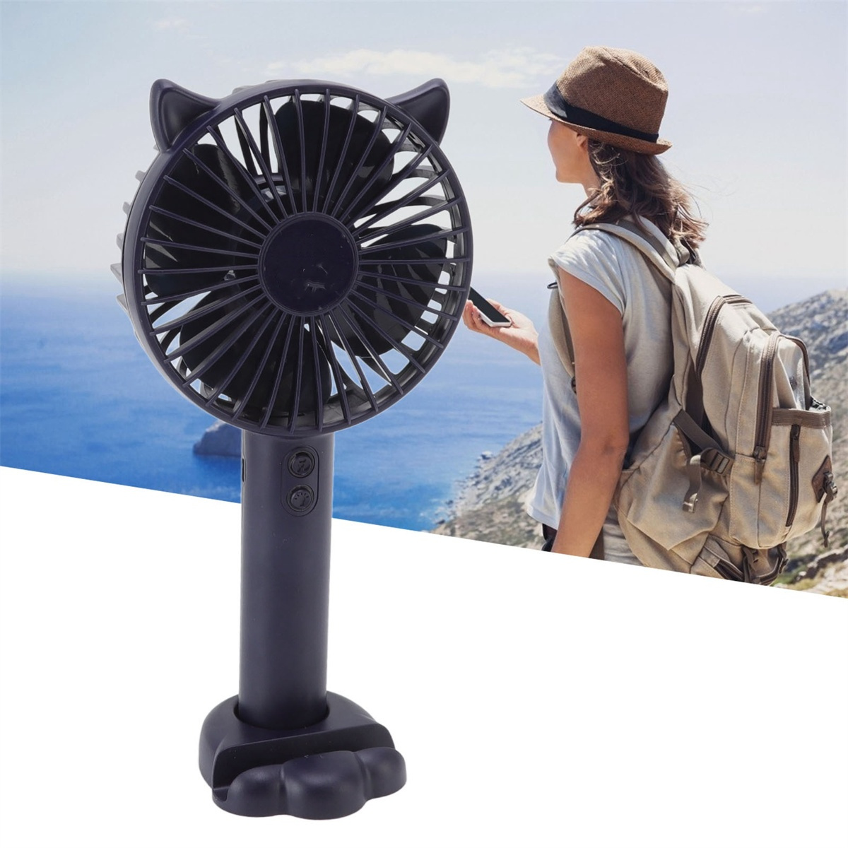 Schwarzer tragbarer Ventilator mit Katzenohren, eine Frau im Hintergrund. Der Ventilator wird von einer Person draußen gehalten.