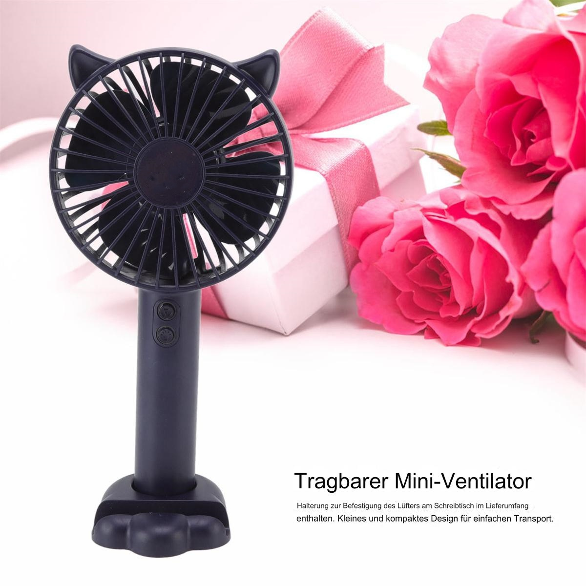 Schwarzer Mini-Ventilator mit Katzenohren, Rosen und Geschenkbox im Hintergrund.