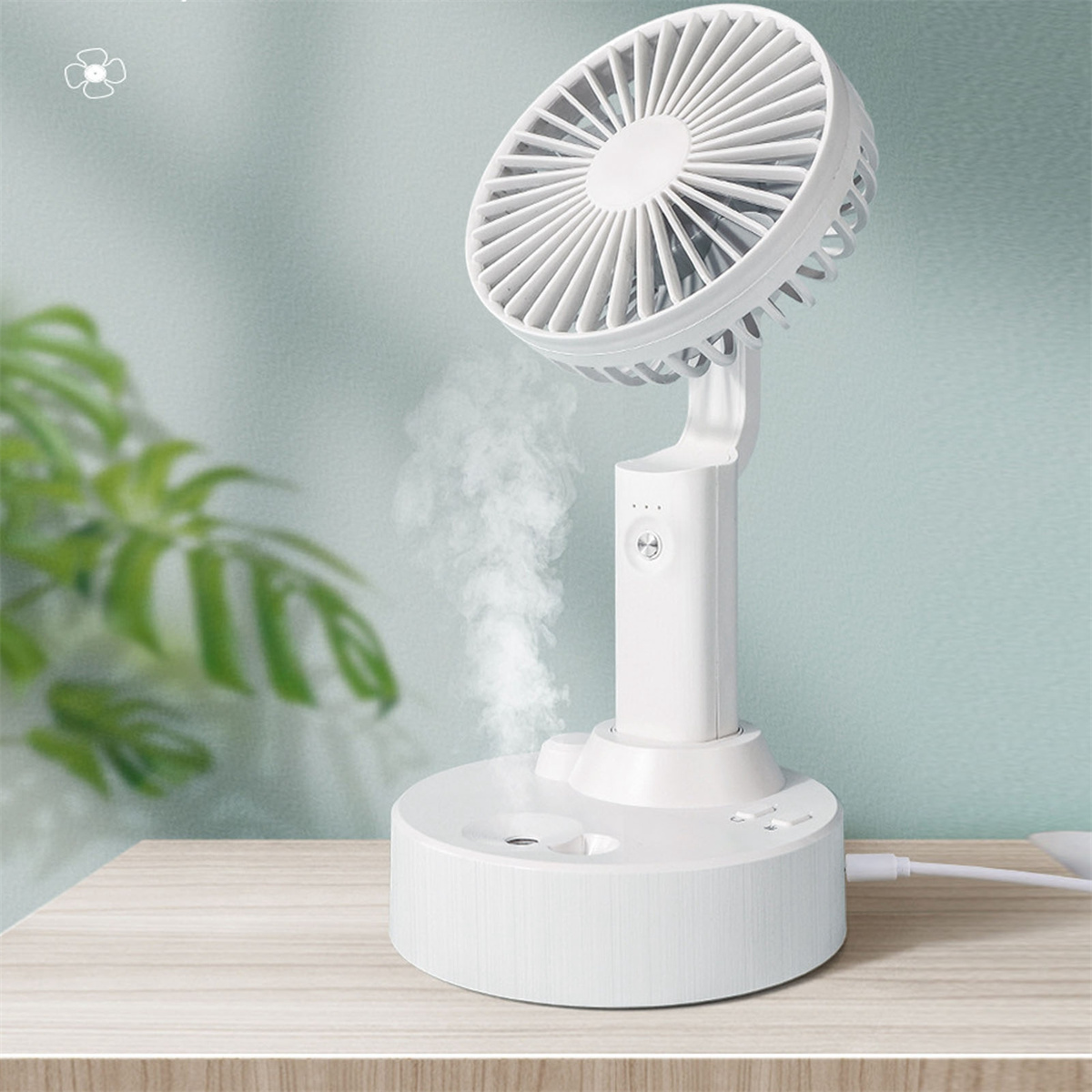 Weißer Ventilator mit Nebel, einstellbarer Winkel. Auf einem Tisch mit einer Pflanze. Nebel kommt heraus.