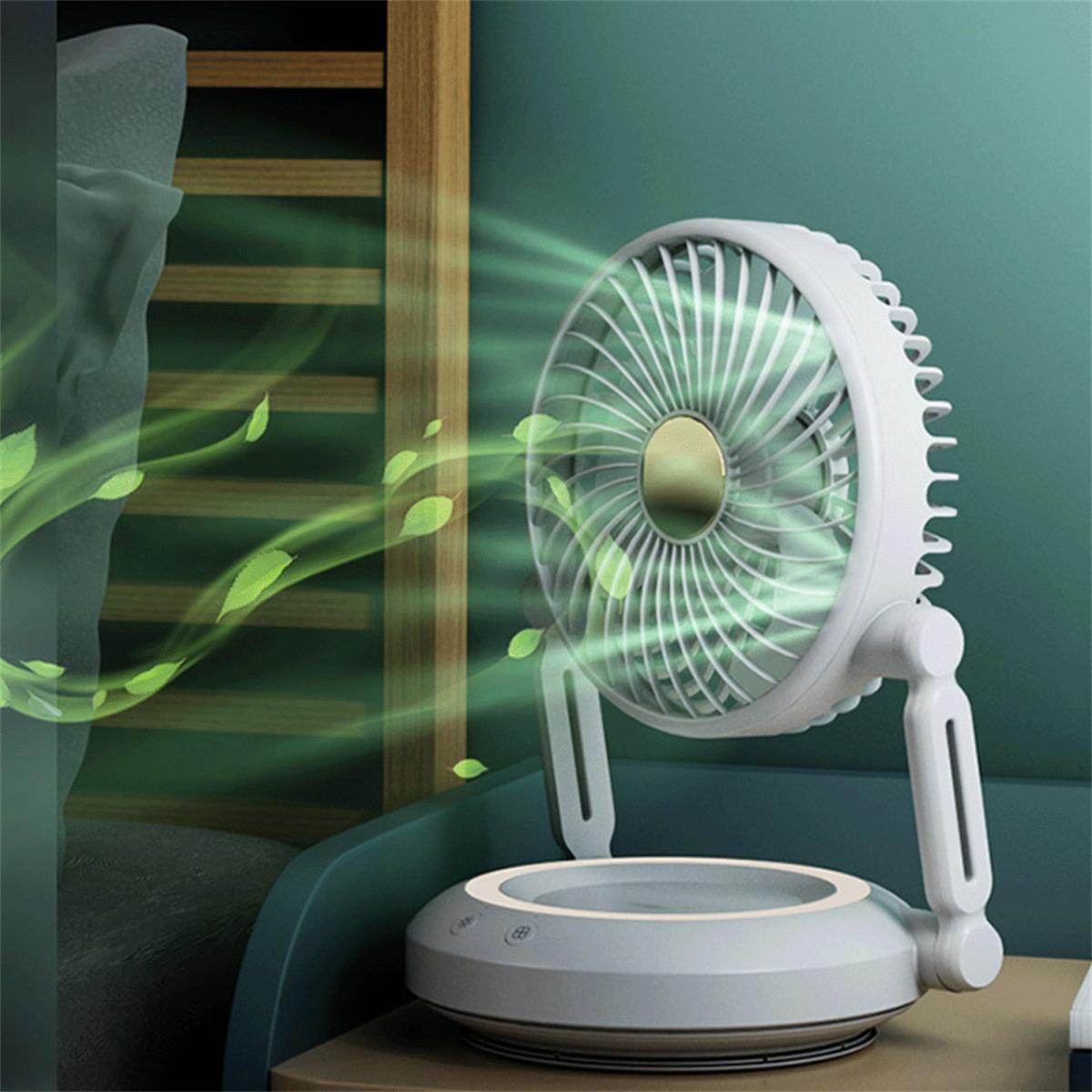 Weiß-grauer Ventilator mit grünen Blättern, der Luft ausstößt. Grüne Blätter in der Luft, auf grünem Hintergrund.