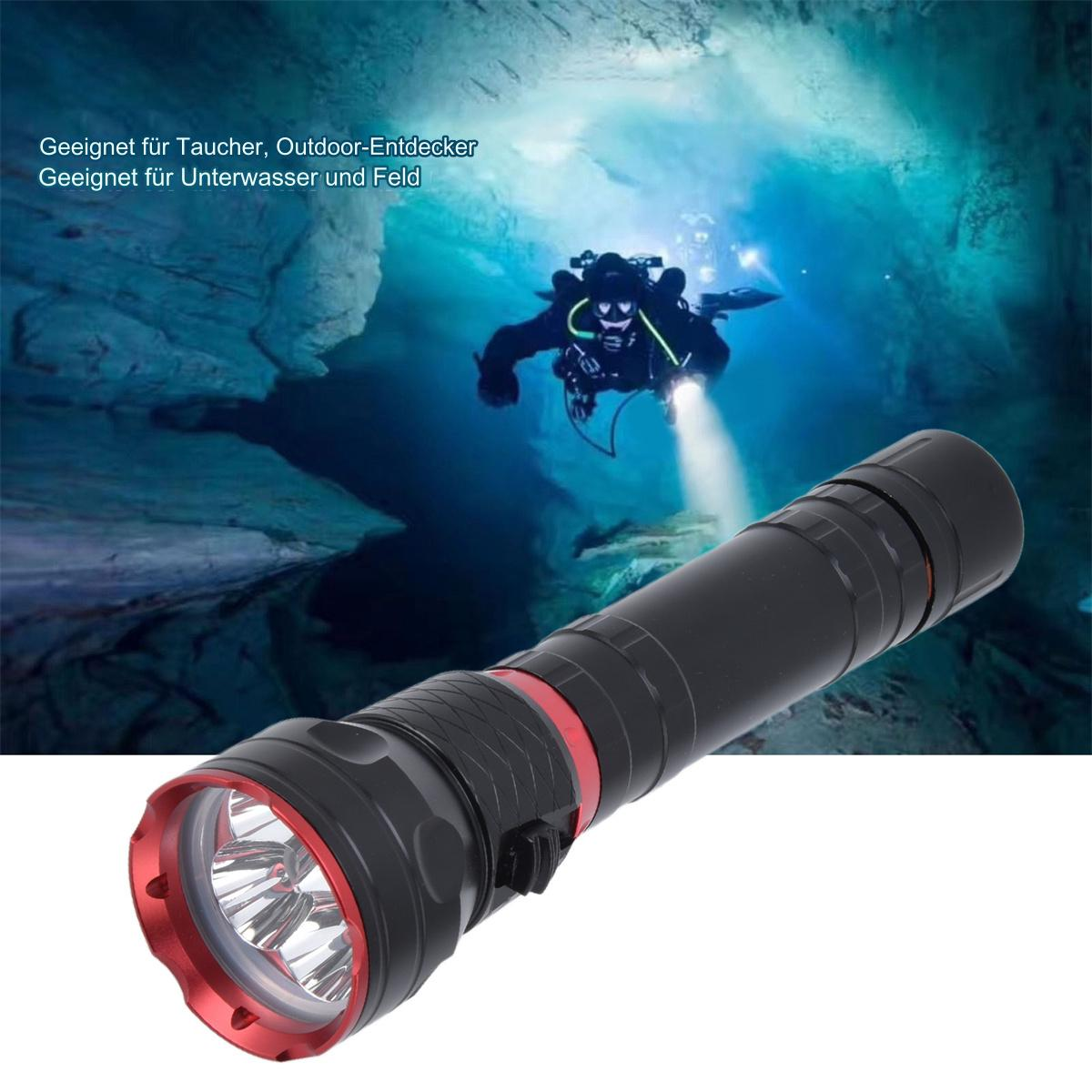 Ein Taucher leuchtet mit einer Taschenlampe in einer Höhle mit malerischer Unterwasseransicht.