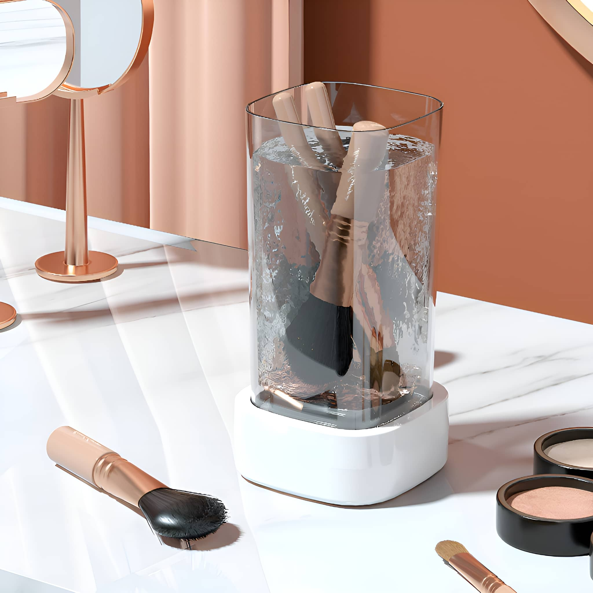Make-up-Pinsel in einem Glas, Wasser und auf Marmor, mit Spiegeln im Hintergrund.