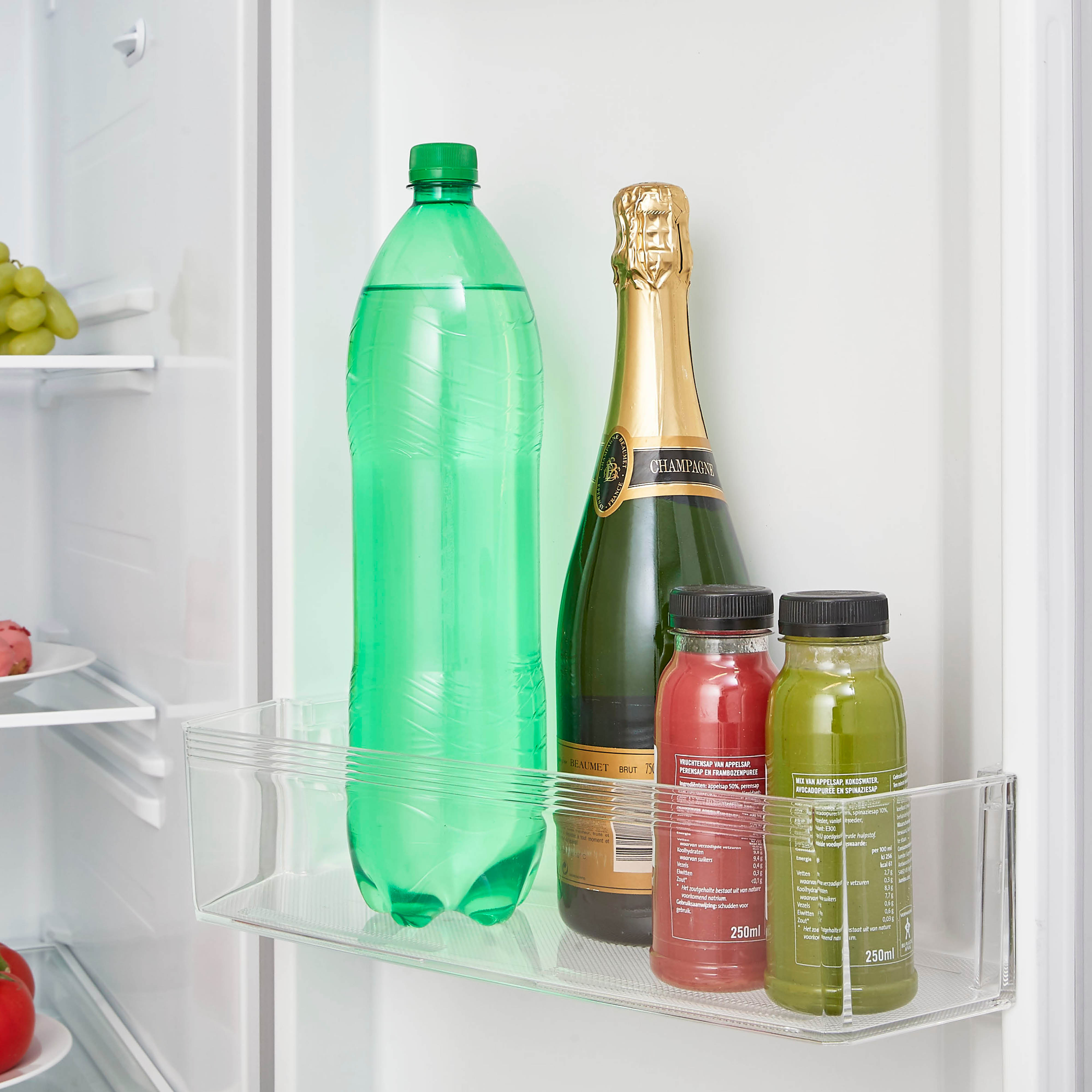 A fridge shelf with water, champagne, and juice bottles.