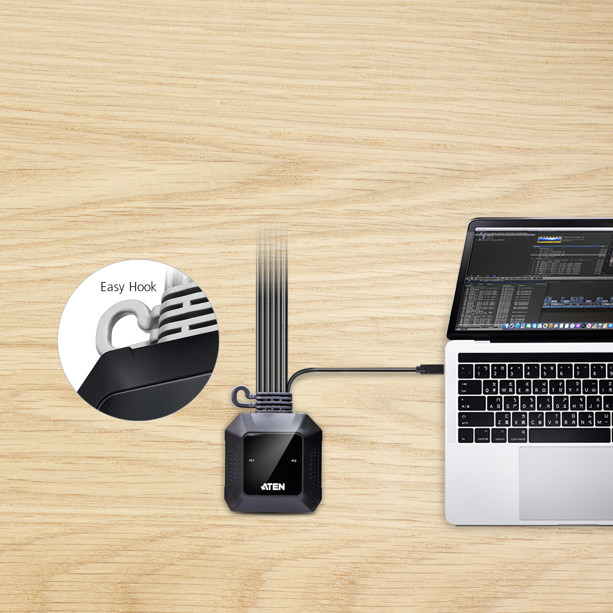 Een laptop verbonden met een zwart apparaat met meerdere kabels. De achtergrond is een houten tafel.