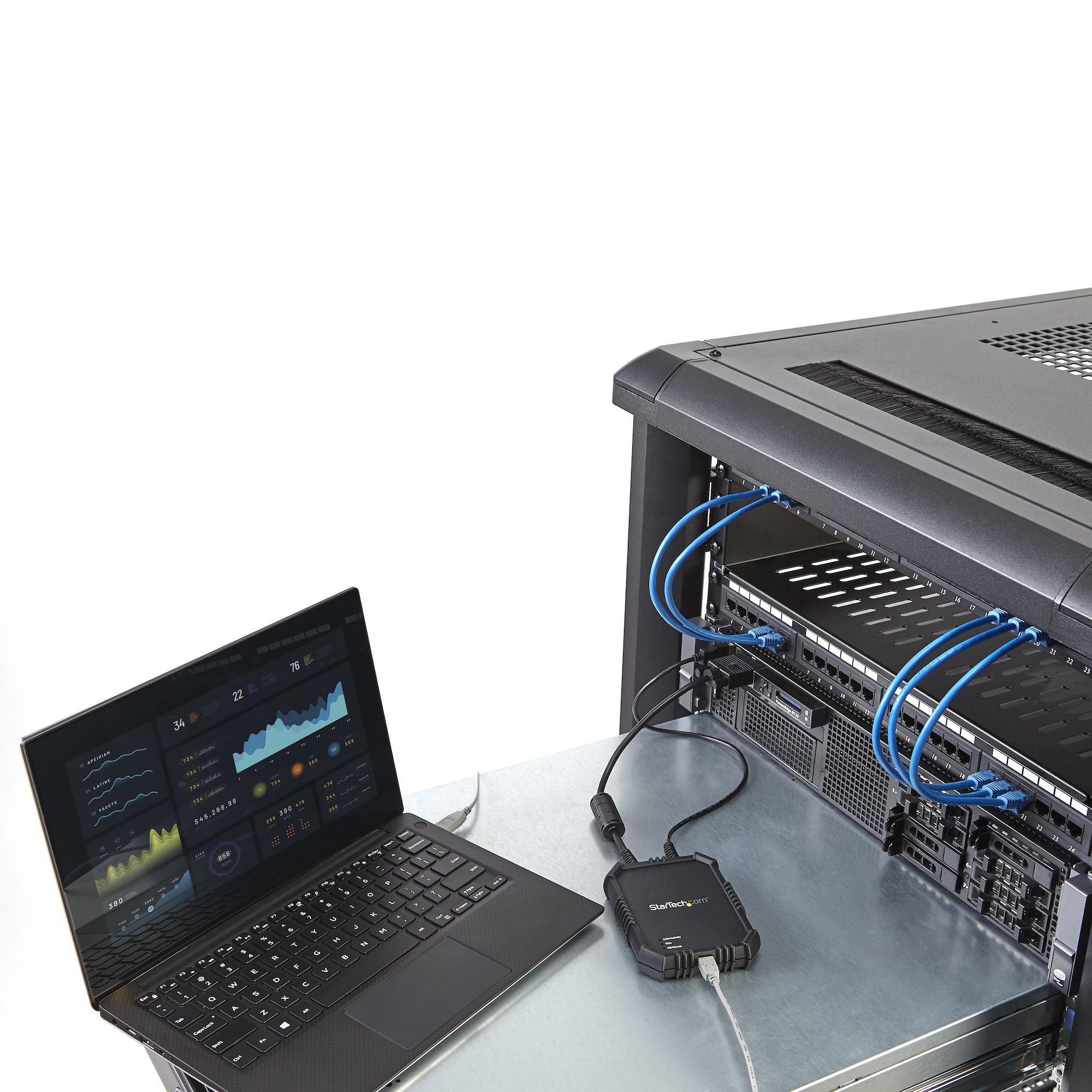 Een laptop met grafieken en gegevens, aangesloten op een serverrack. Een zwarte StarTech-adapter is zichtbaar.
