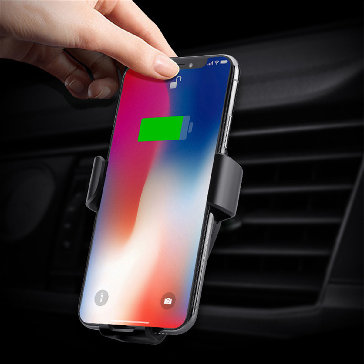 Eine Hand legt ein Telefon in eine schwarze Autotelefonhalterung. Das Telefon lädt.